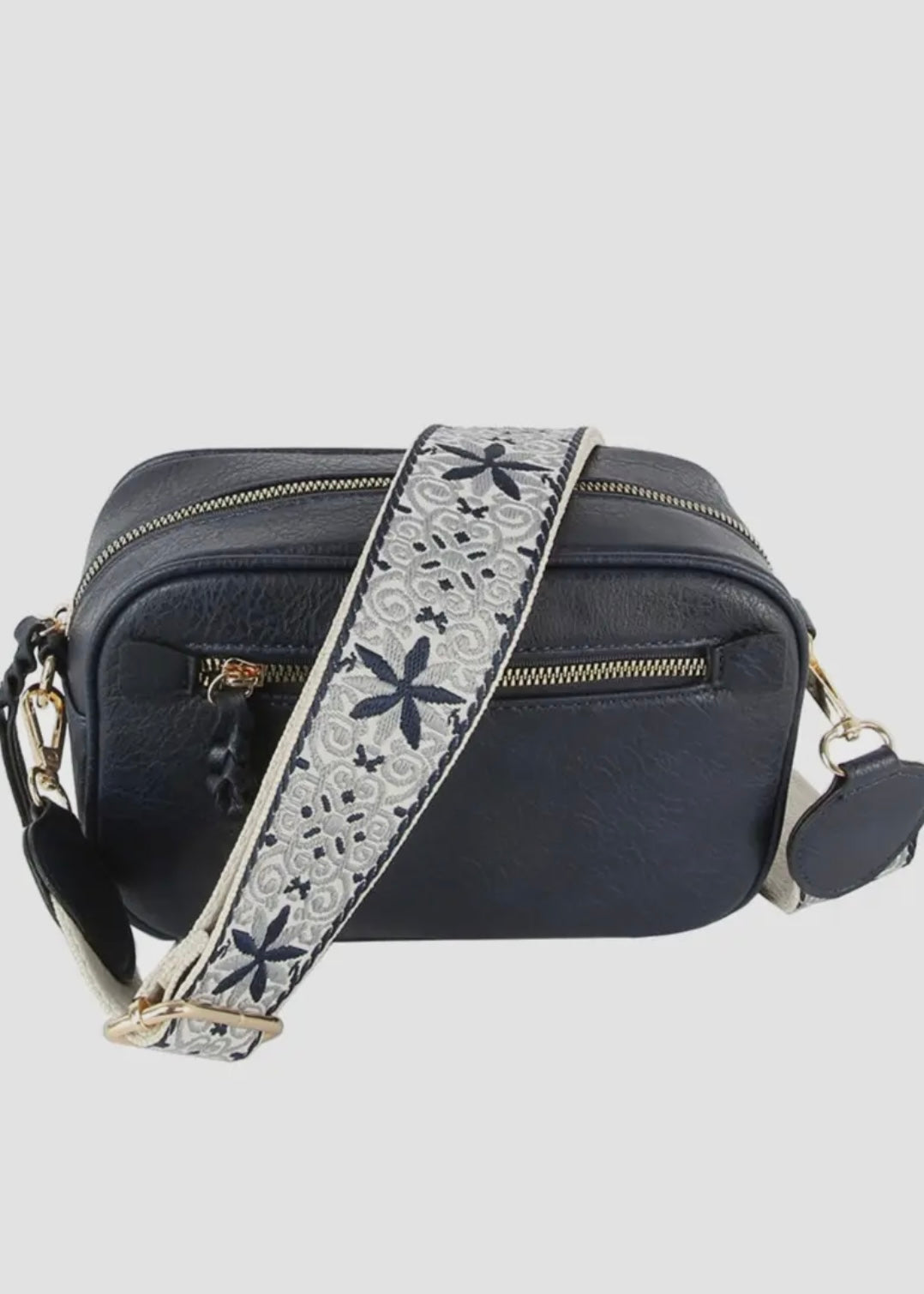 Vegan leather boho style purse with detailed guitar strap. Purse has a zip closure, back zip pocket, gold tone hardware and detachable strap.
8.5 x 5.5 x 3”. Shown in navy.