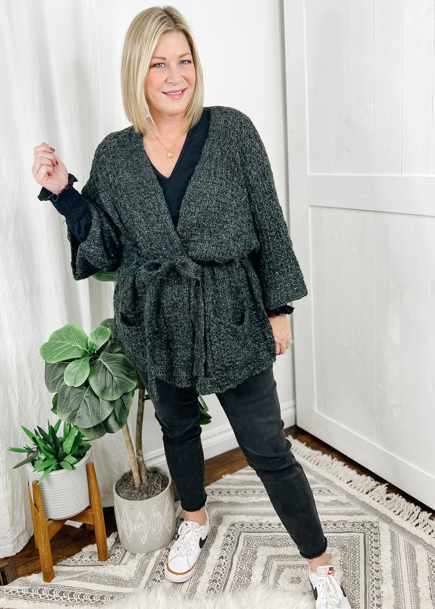 Charcoal knit cardigan with open front and belt for self tie closure. Cardigan has self tie belt, open front, bell sleeves and front pockets.