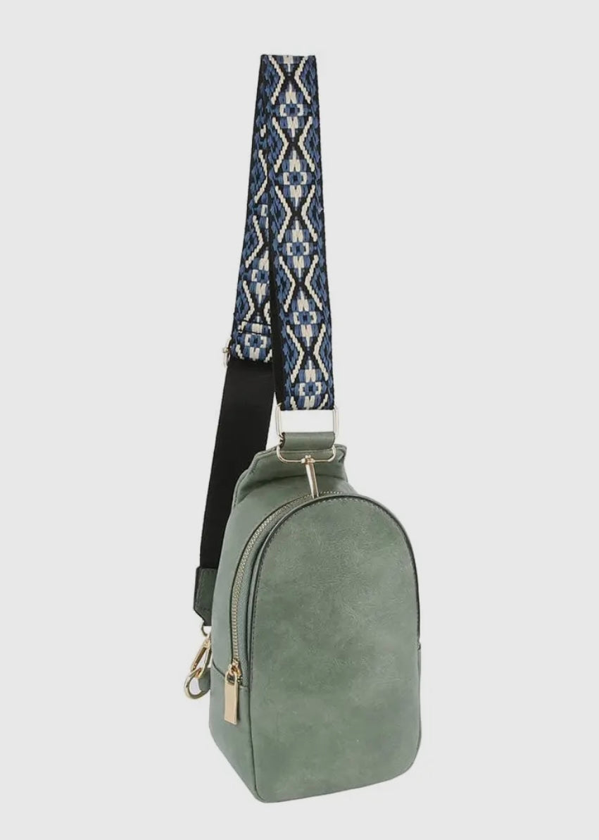 Made with vegan leather and featuring a zip top closure and gold-tone hardware, this bag is perfect for carrying personal items. The adjustable strap and card slots make it a practical choice for on-the-go activities. Dimensions: L 5.75 * H 10.75 * W 3 inches. Shown in denim