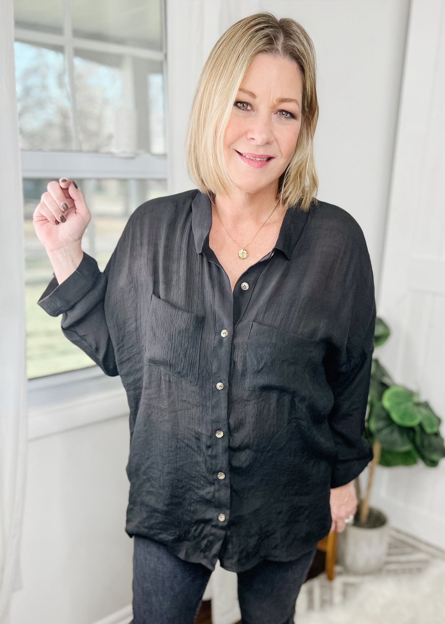 Black semi sheer button down with front breast pockets, collar, and sleeve strap to roll sleeves.  