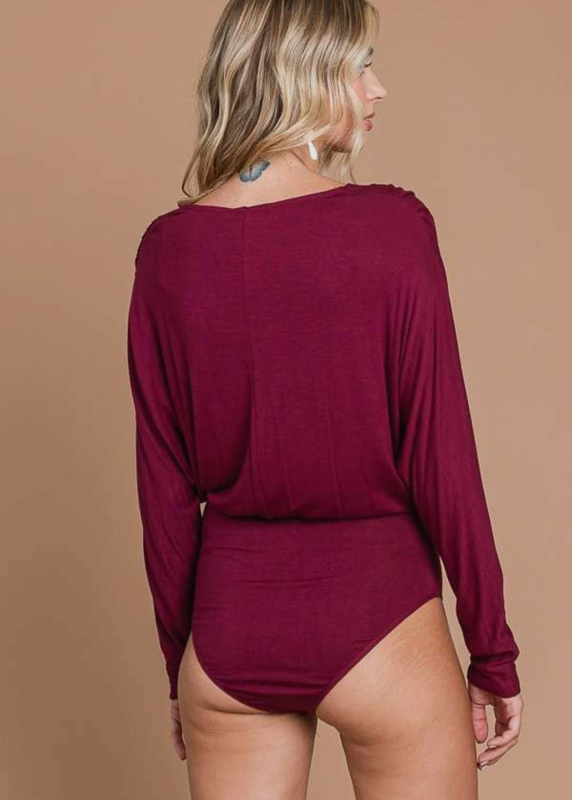 Long sleeve bodysuit with full coverage in a lightweight burgundy fabric. Bodysuit has wrap front look with a deep v neckline.