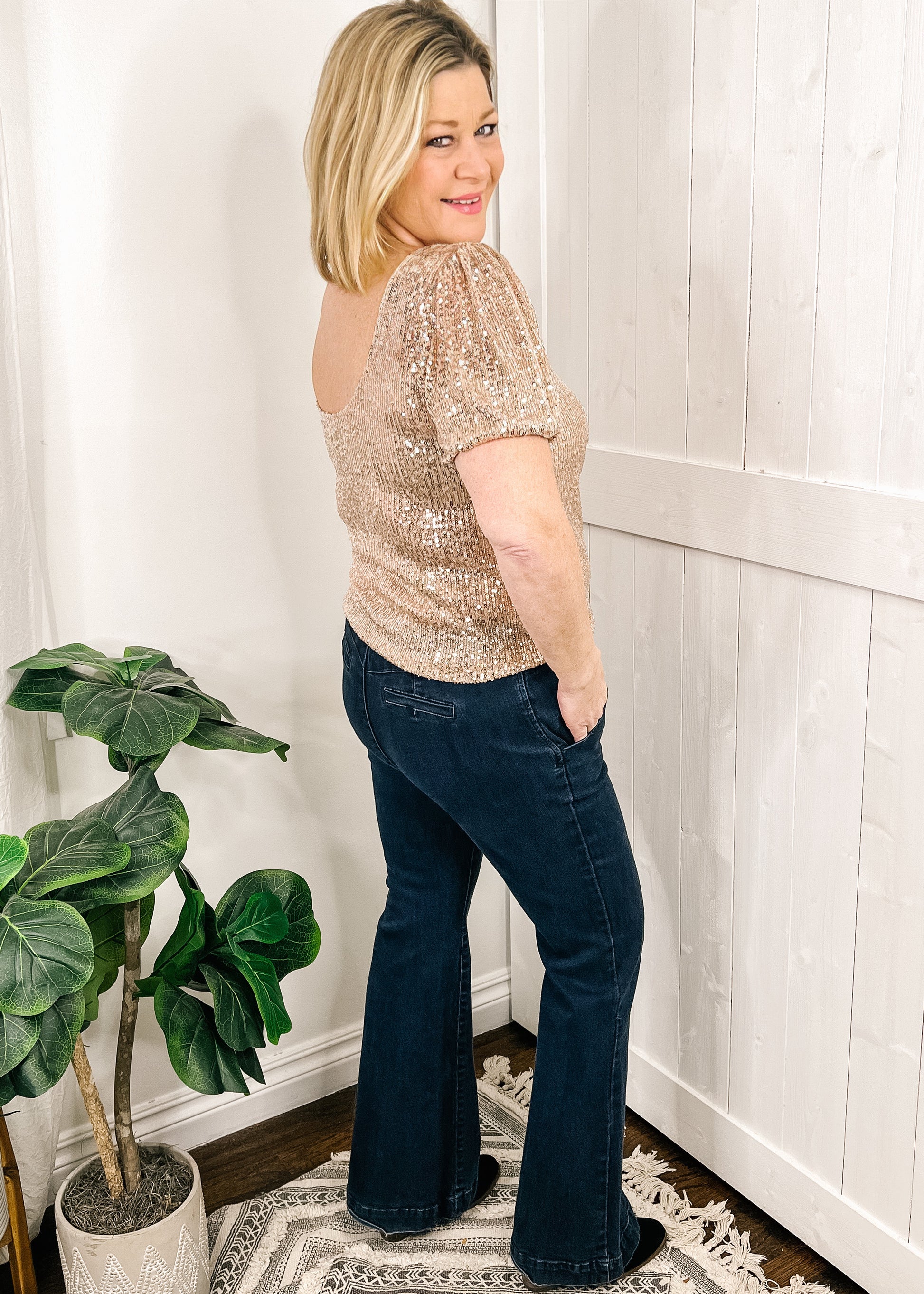Rose gold sequin top with short puff sleeves, rounded neckline and fitted bodice. Back of top scoops down at neckline.