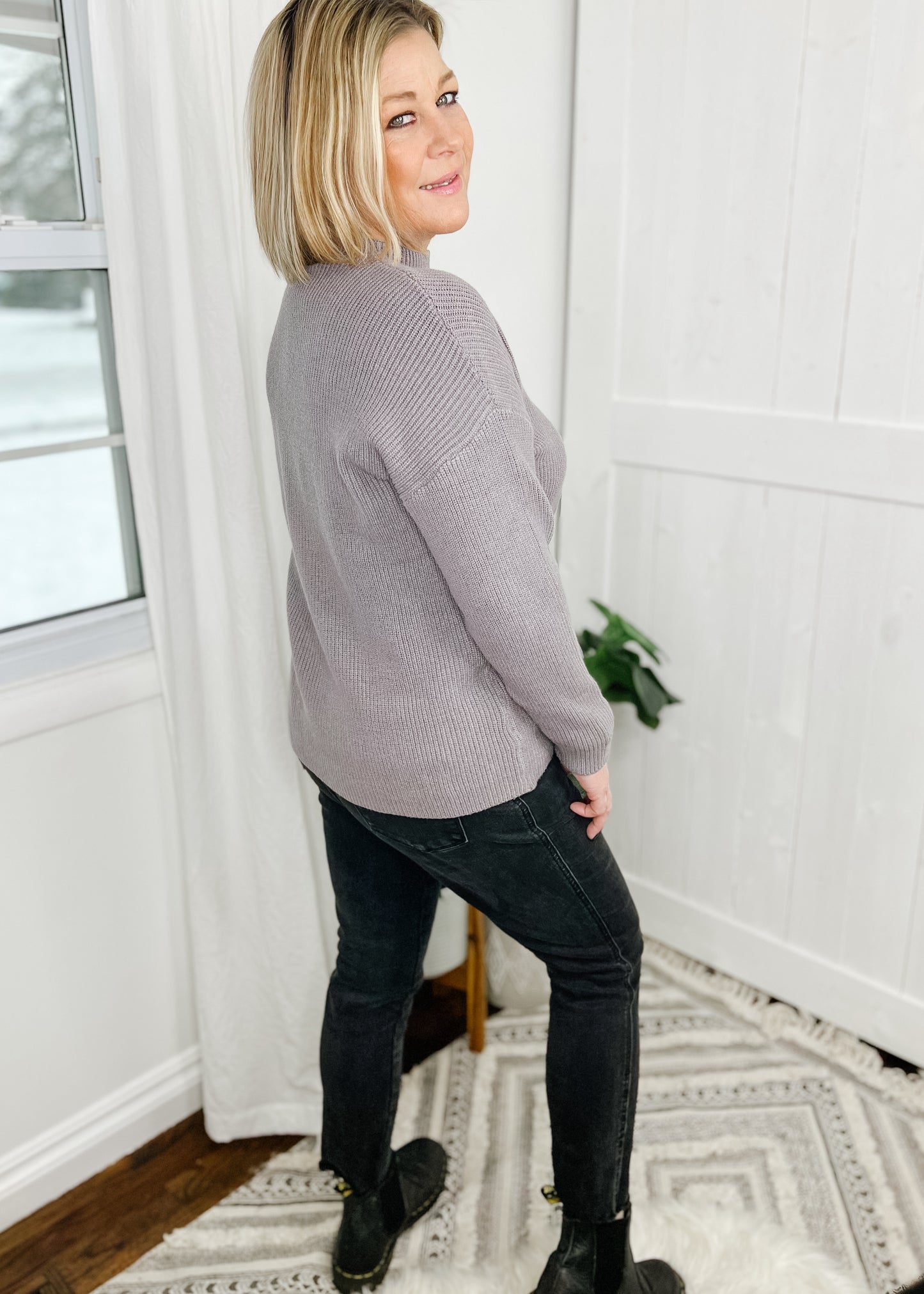 Gray sweater with a ribbed knit and a solid knit front pocket on left breast. Sweater features a mock neckline, drop shoulder and long sleeves.