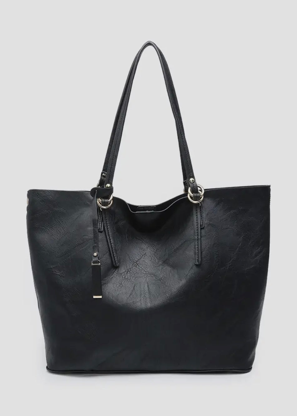 2 in 1 vegan leather tote. 
-Inner Bag: Included with 1 zipper pocket and 2 accessory pockets, herringbone lining
-Straps: Removable adjustable shoulder strap
-Closure: Magnetic snap closure
-Hardware: Gold-tone hardware
-Material: Vegan leather
Shown in black