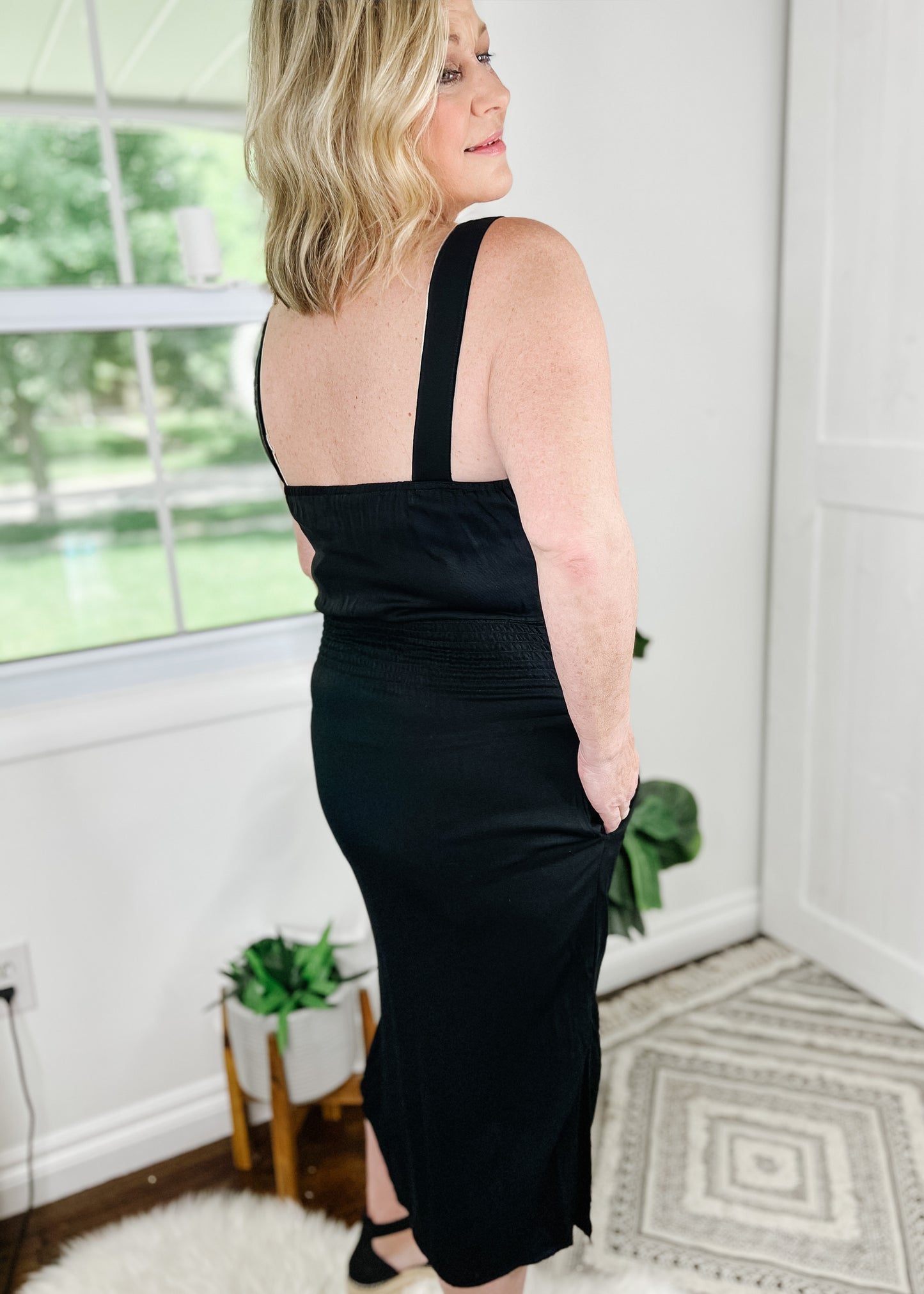 Black midi dress. Black button up dress with functional wood buttons, V-Neckline, sleeveless and side slits. Dress also features pockets.