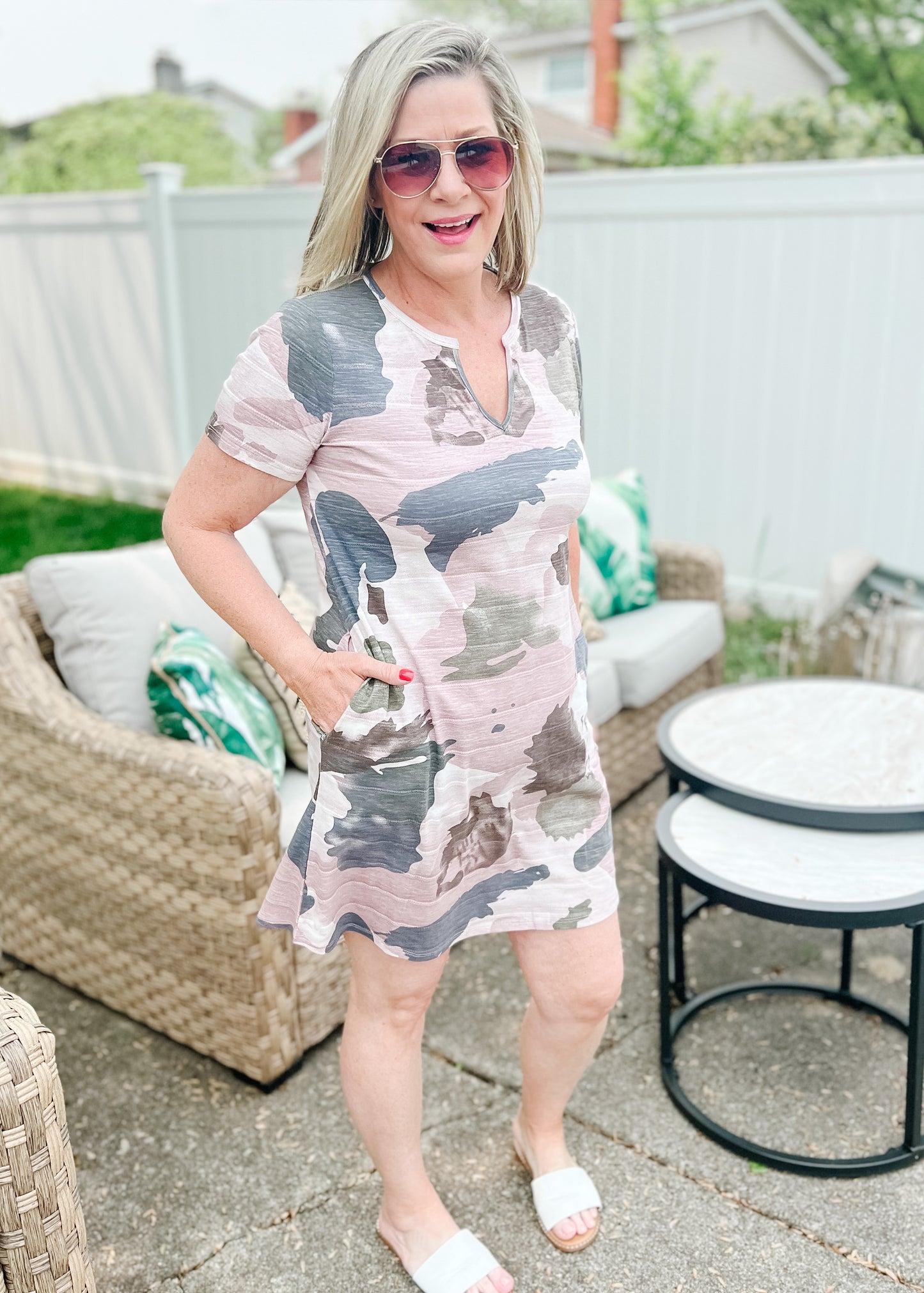 Camo print mini dress purples, gray and creams. Fabric is soft and has a 1 inch ribbed detail throughout. Dress features short sleeves, small v-neckline and side pockets.