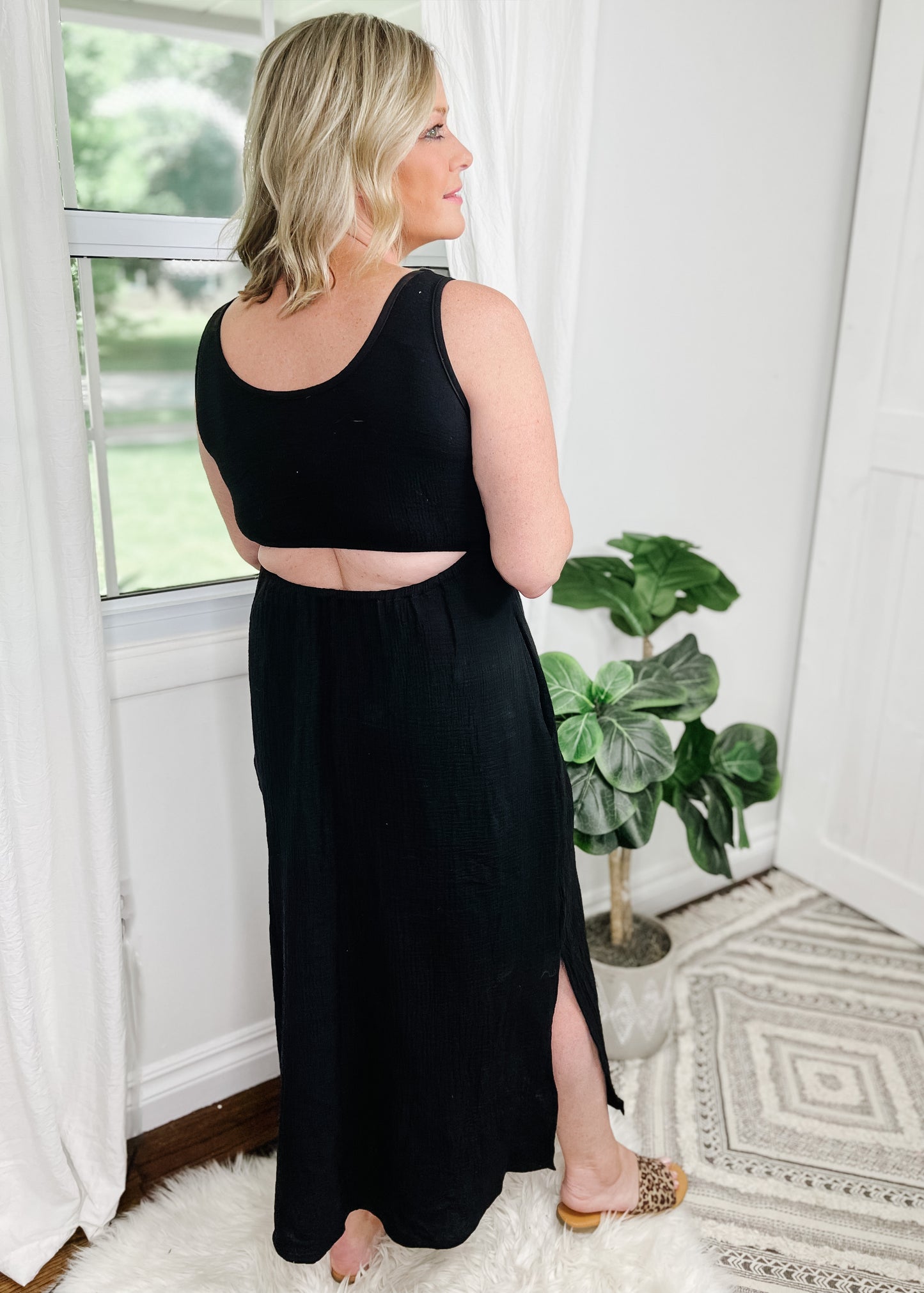 Midi cut out dress black and light gauze fabric. Tank top style sleeves with 2 rows of elastic about an Ince apart for some pretty details. Side slits on bottom curved hemline. Cut out detail is in back above waistline.