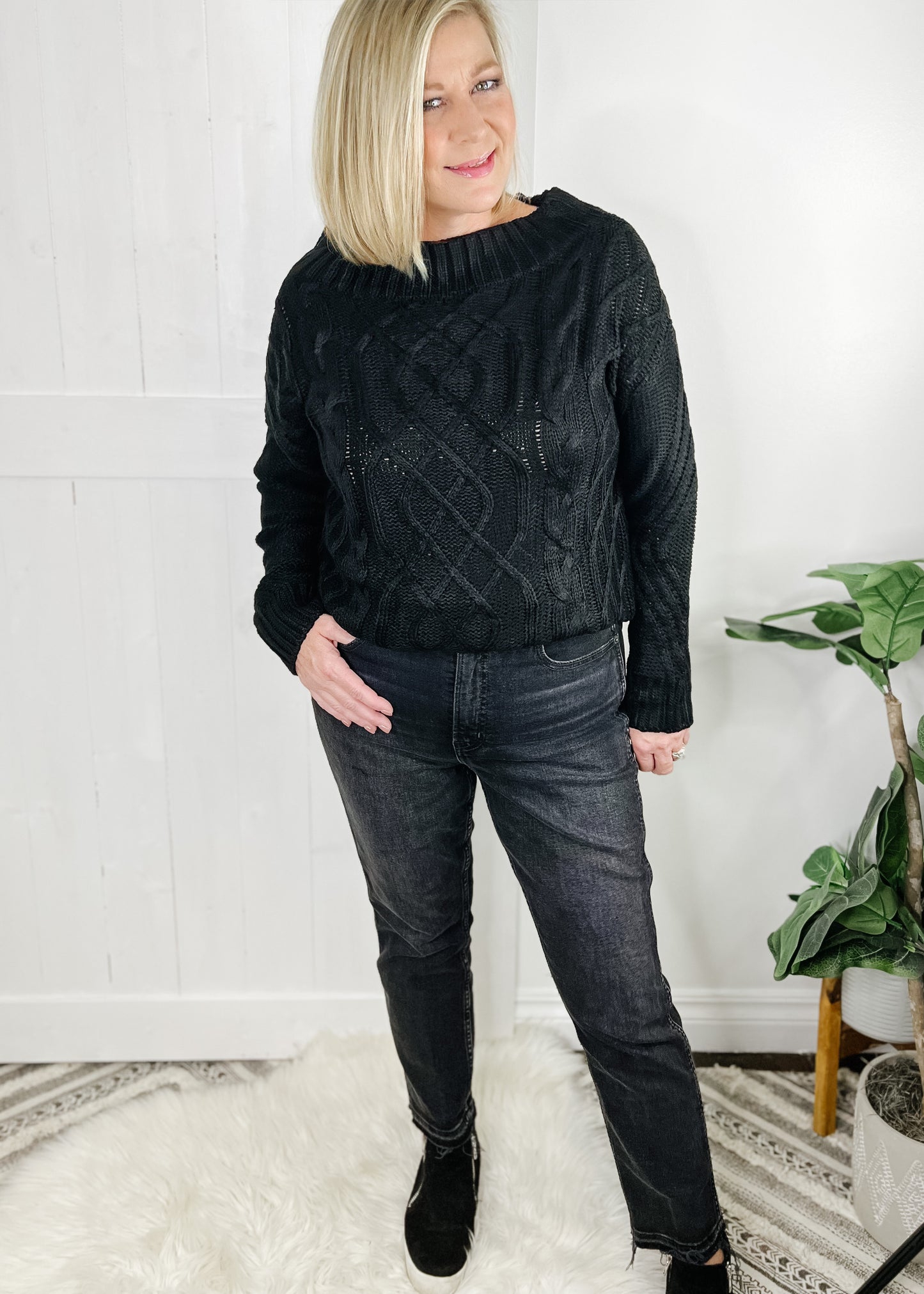 black off the shoulder cable knit sweater with long sleeves.