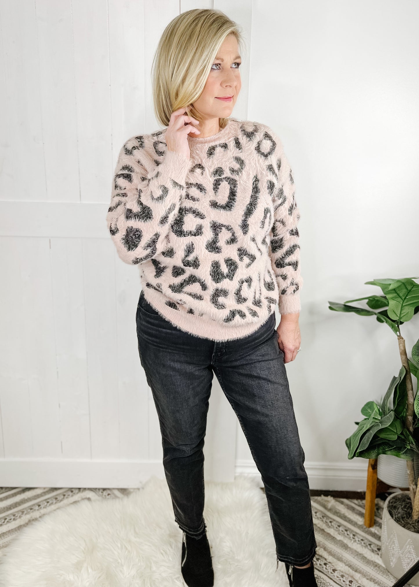 pink open back sweater in leopard print with long sleeves and rounded neckline.