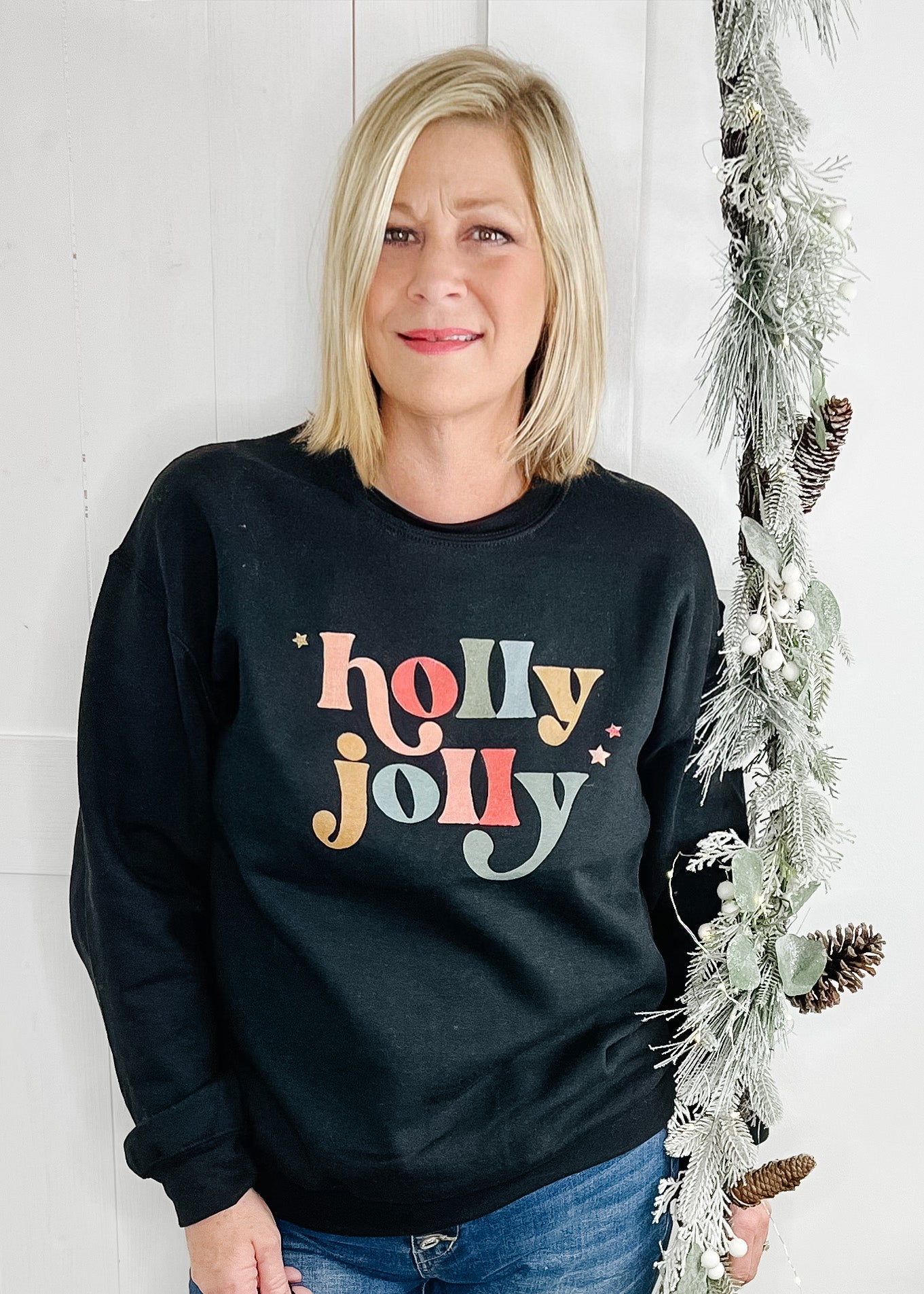 Black Holly Jolly sweatshirt. Holly jolly in multi color with 3 small stars.