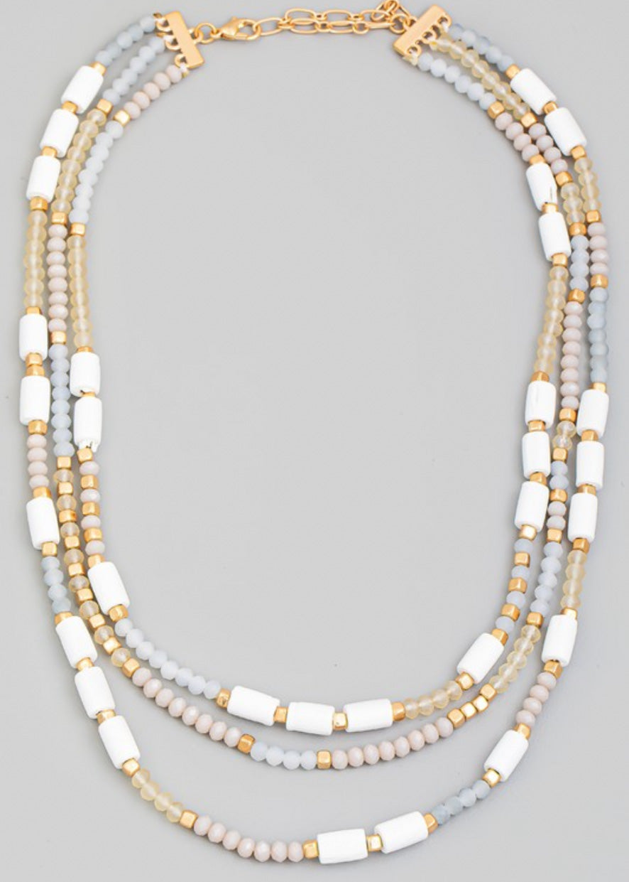 Beaded necklace with multi beads in small rounded frost and gold beads with larger white beads sporadically throughout