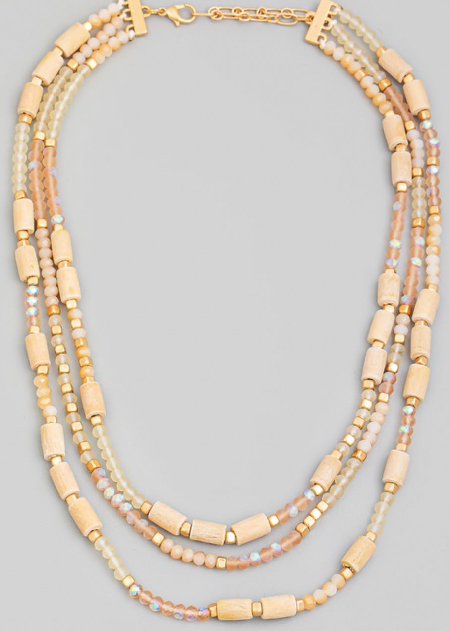 Beaded necklace with multi beads in small rounded frost and gold beads with larger tan beads sporadically throughout