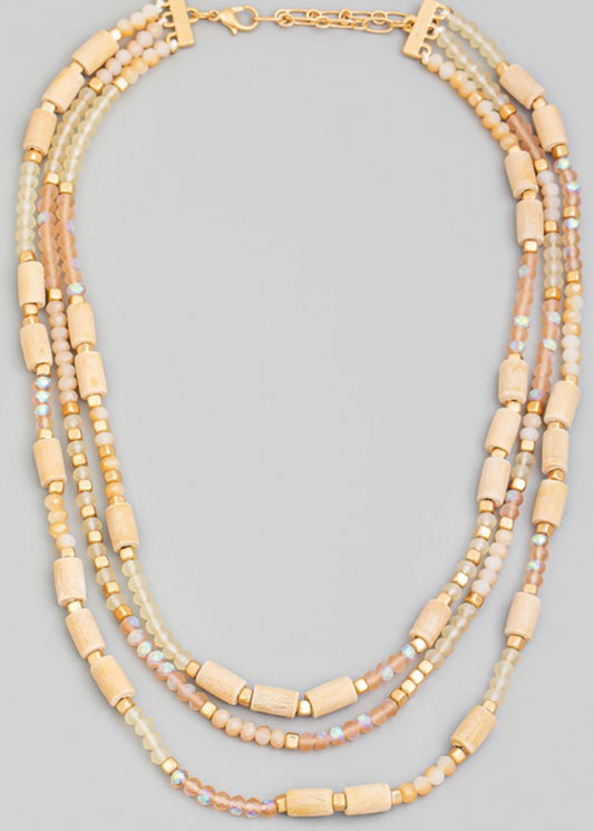Beaded necklace with multi beads in small rounded frost and gold beads with larger tan beads sporadically throughout