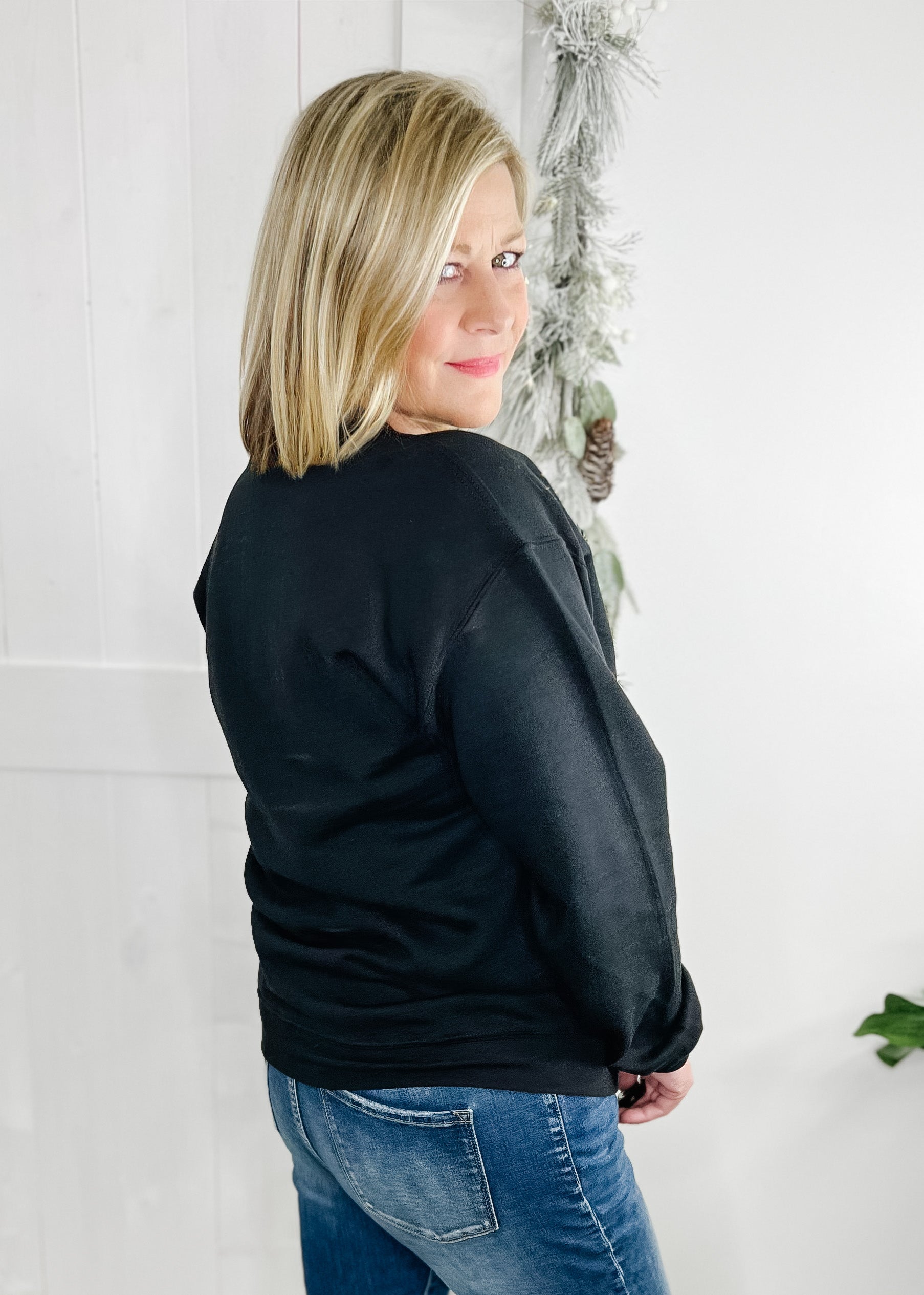 Black Holly Jolly sweatshirt. Holly jolly in multi color with 3 small stars.