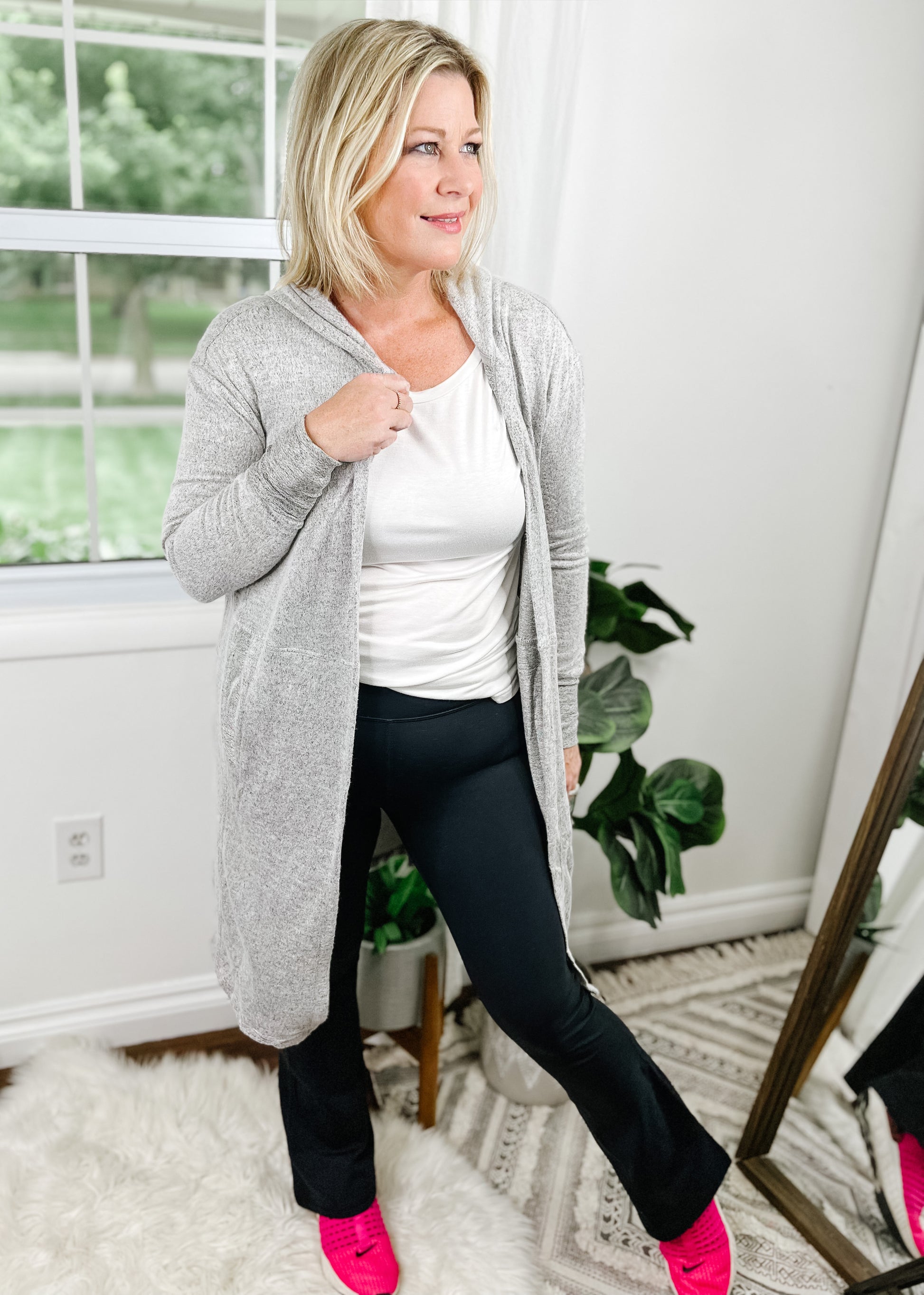 Gray cardigan with hood. Open front, long sleeves, side pockets and curved hemline. Shown with our flare leggings. 