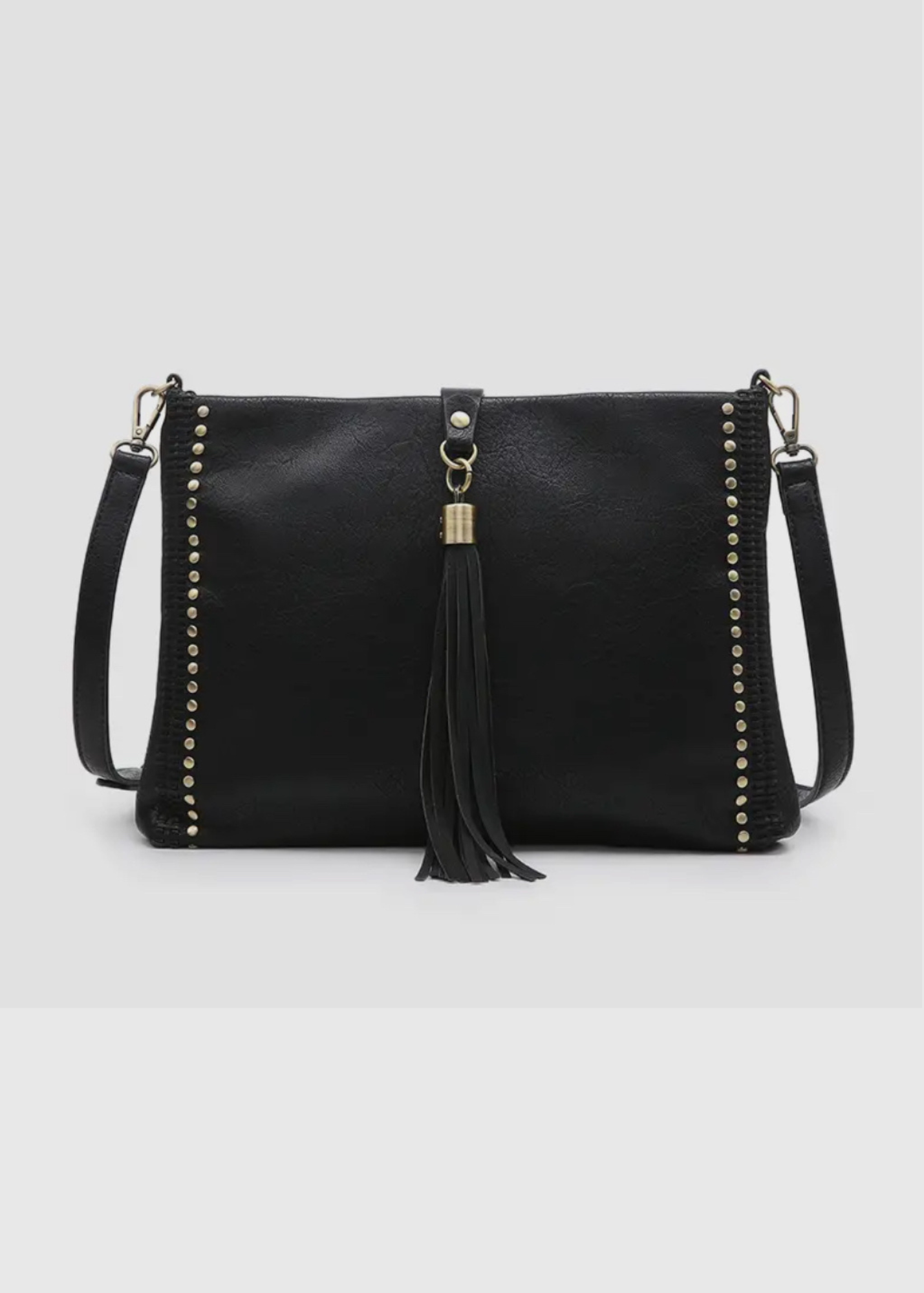 black purse made of soft vegan leather. Purse is rectangular with silver studs going up the sides and a ling tassel wit silver hardware that folds over the top to close purse. Strap is crossbody length and is adjustable. 