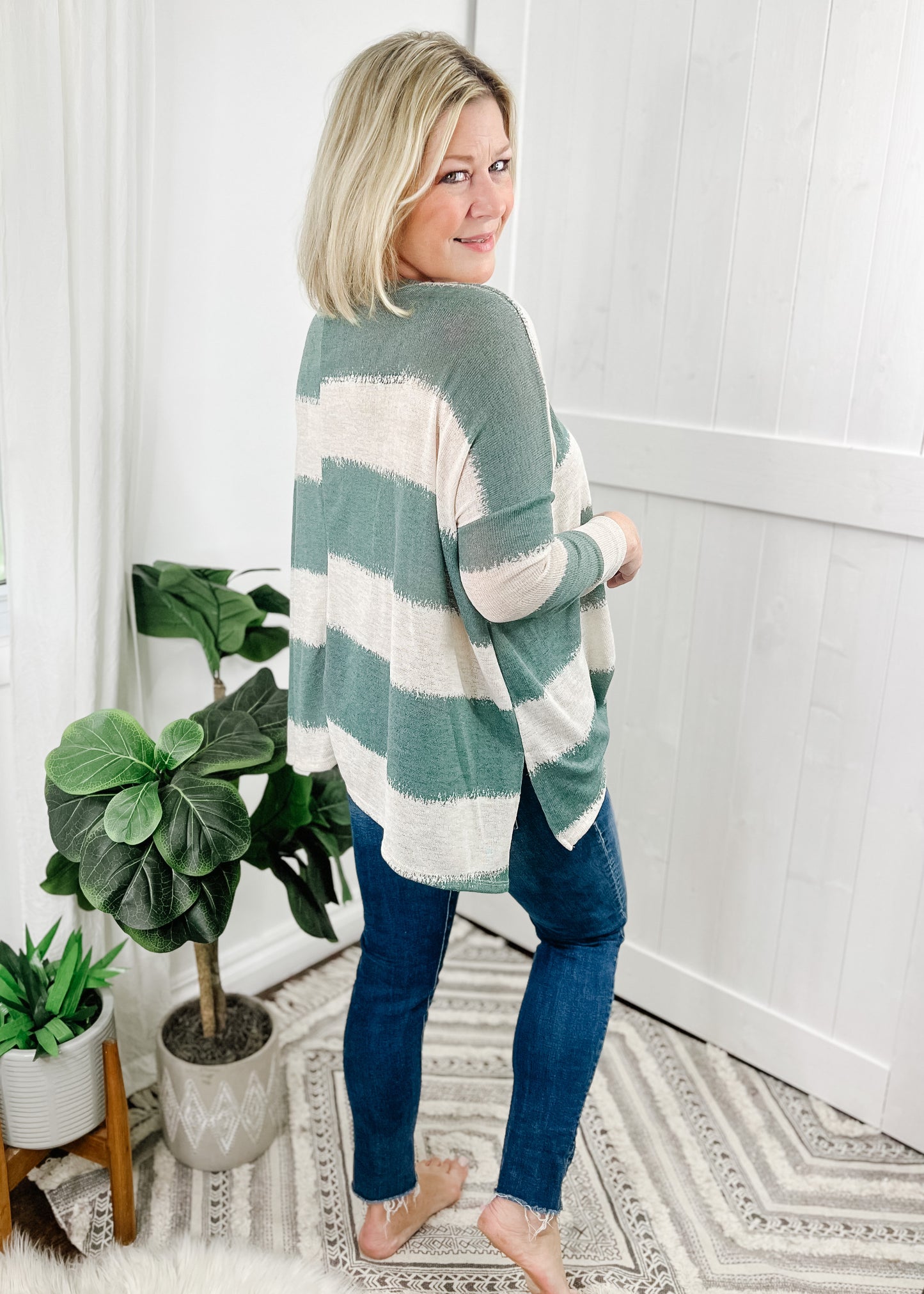 Sage green striped top with contrasting cream stripes, stripes are wide and fade into each other. V-neckline, drop shoulder and relaxed fit. 