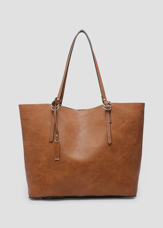 2 in 1 vegan leather tote. 
-Inner Bag: Included with 1 zipper pocket and 2 accessory pockets, herringbone lining
-Straps: Removable adjustable shoulder strap
-Closure: Magnetic snap closure
-Hardware: Gold-tone hardware
-Material: Vegan leather
Shown in brown