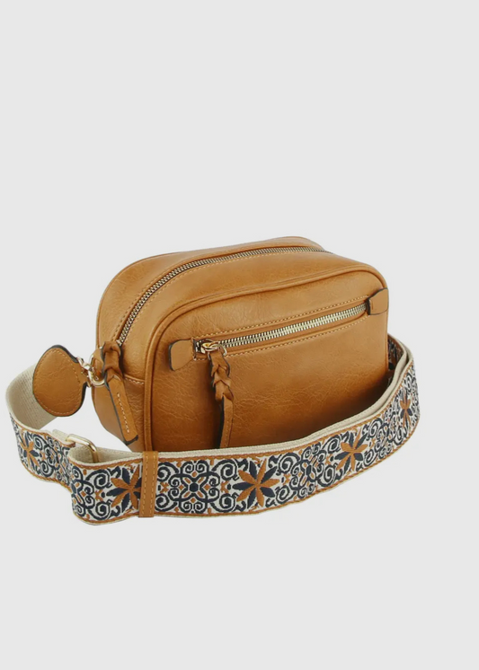 Vegan leather boho style  purse with detailed guitar strap. Purse has a zip closure, back zip pocket, gold tone hardware and detachable strap.
8.5 x 5.5 x 3”. Shown in brown.