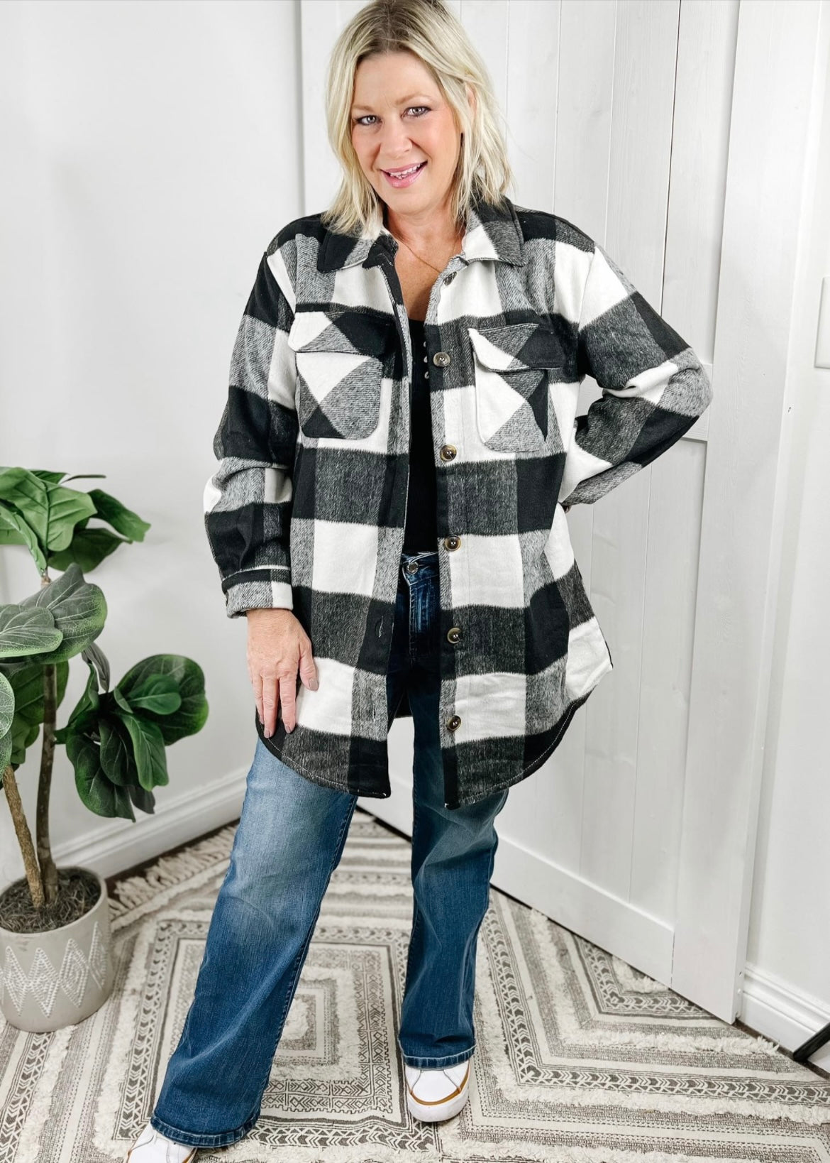 Shacket in a black and white buffalo check print. Shacket has long sleeves, collar, front breast pockets, button closure and slightly longer in length. 