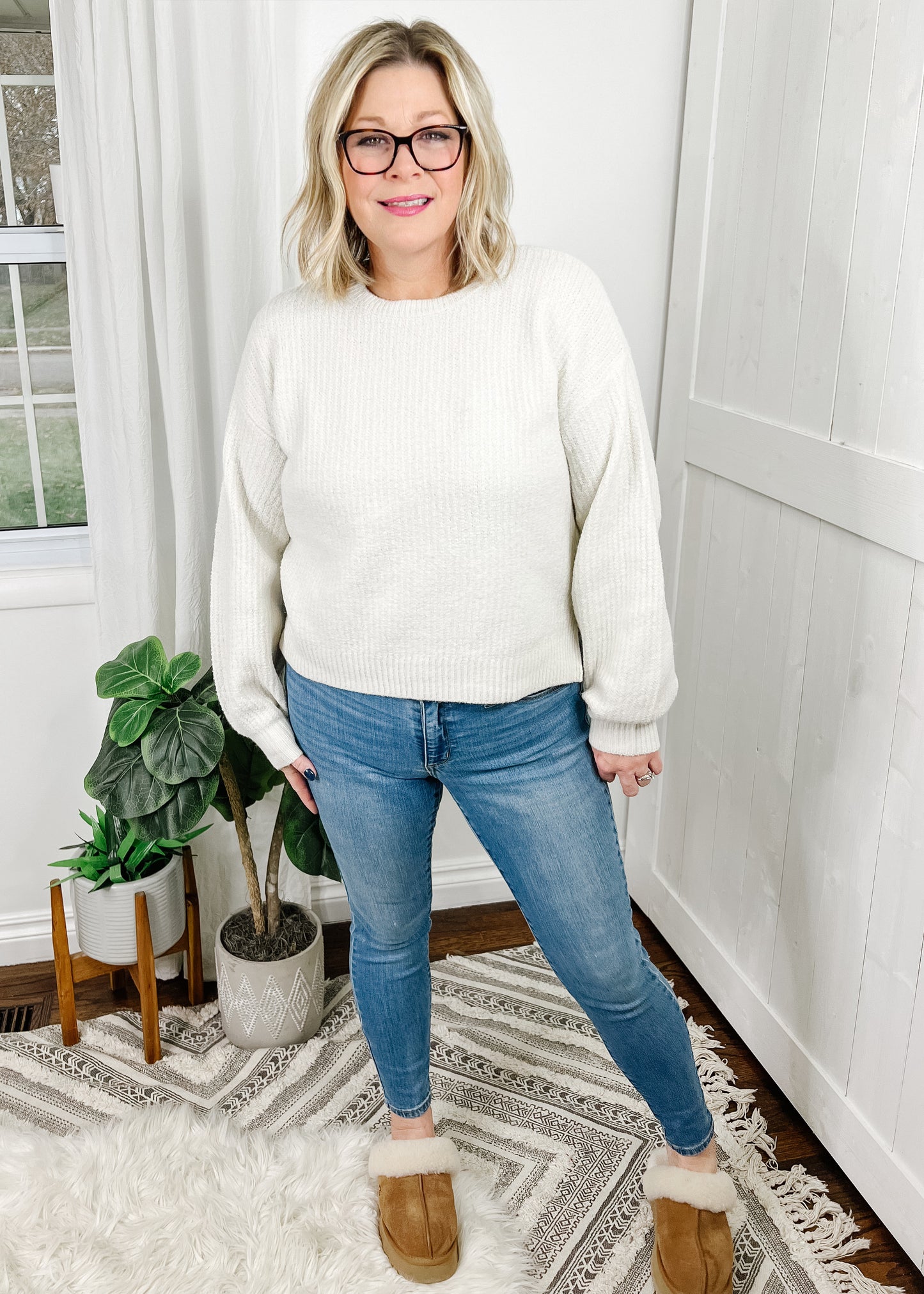 Cream crew neck sweater with a ribbed knit, relaxed fit and side slits. Sweater is long sleeve with a slight bubble effect at wrist. 