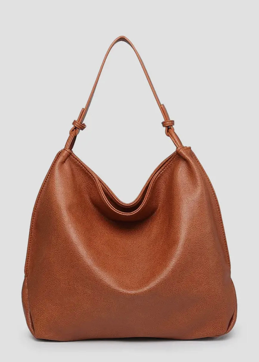 Brown vegan leather slouch bag/tote with inner slip and zip pocket and inner zip compartment. Bag has a zipper closure, back zipper pocket and is made of a soft vegan leather. Size: 13x16x5.5