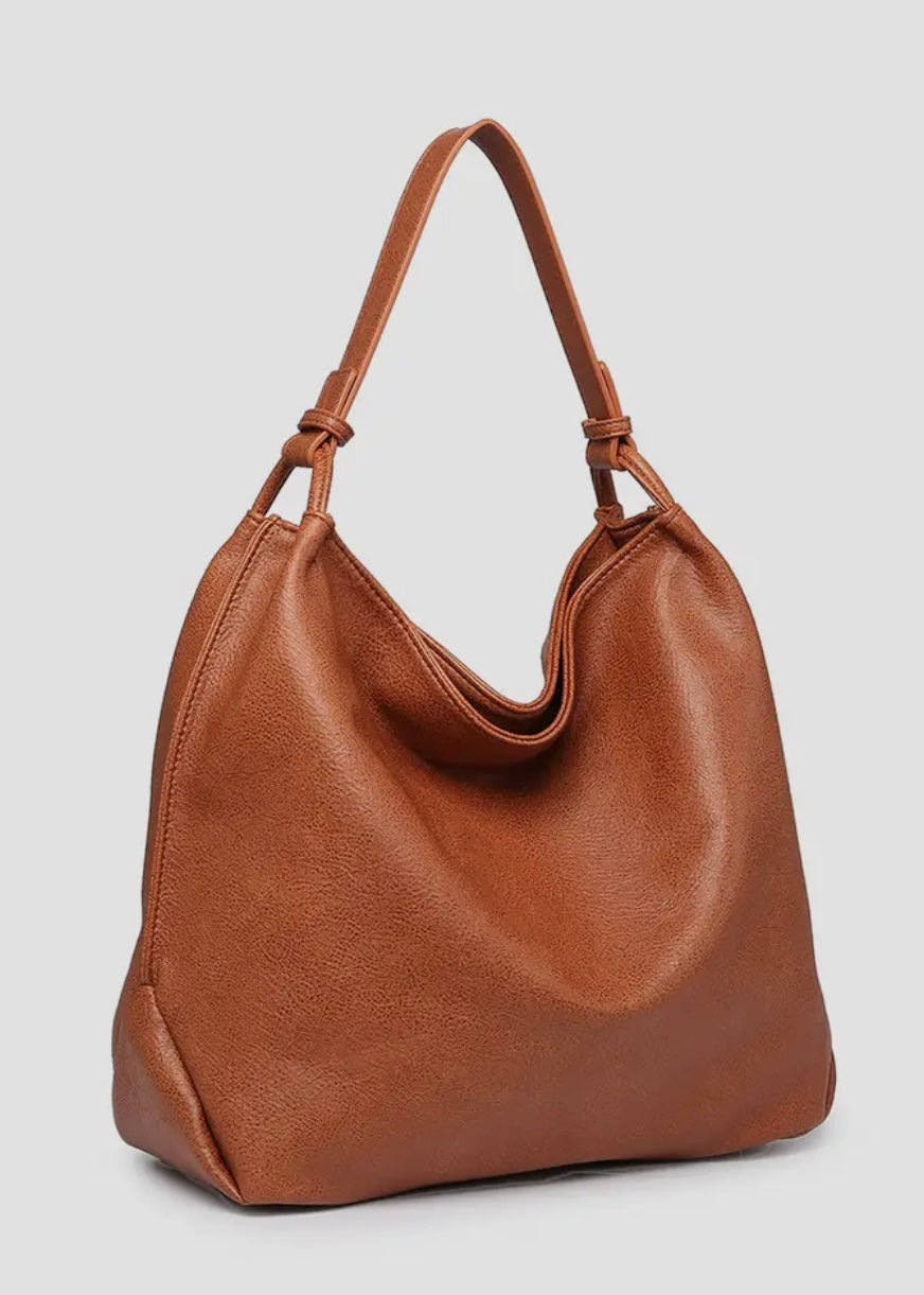 Brown vegan leather slouch bag/tote with inner slip and zip pocket and inner zip compartment. Bag has a zipper closure, back zipper pocket and is made of a soft vegan leather. Size: 13x16x5.5