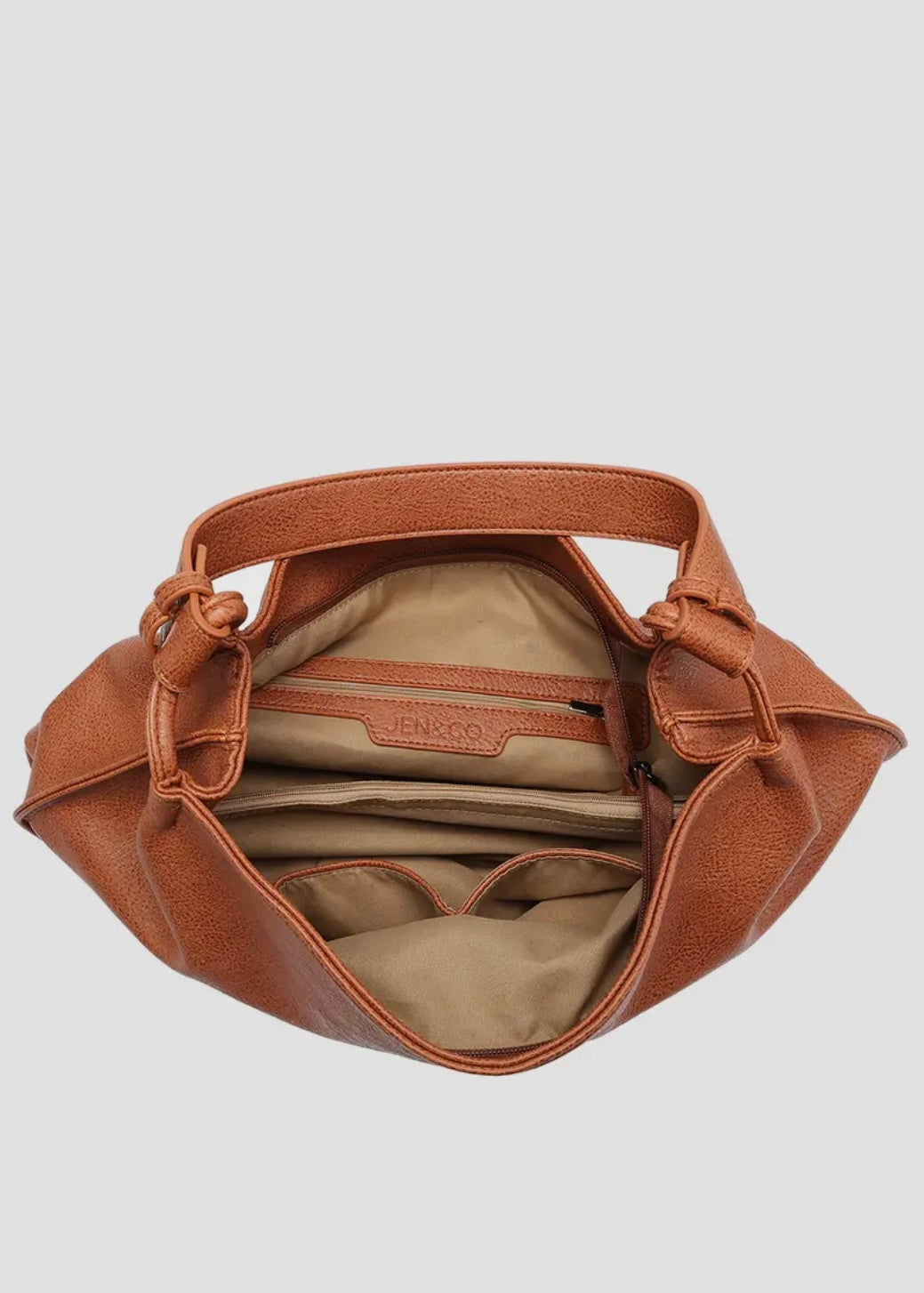 Brown vegan leather slouch bag/tote with inner slip and zip pocket and inner zip compartment. Bag has a zipper closure, back zipper pocket and is made of a soft vegan leather. Size: 13x16x5.5