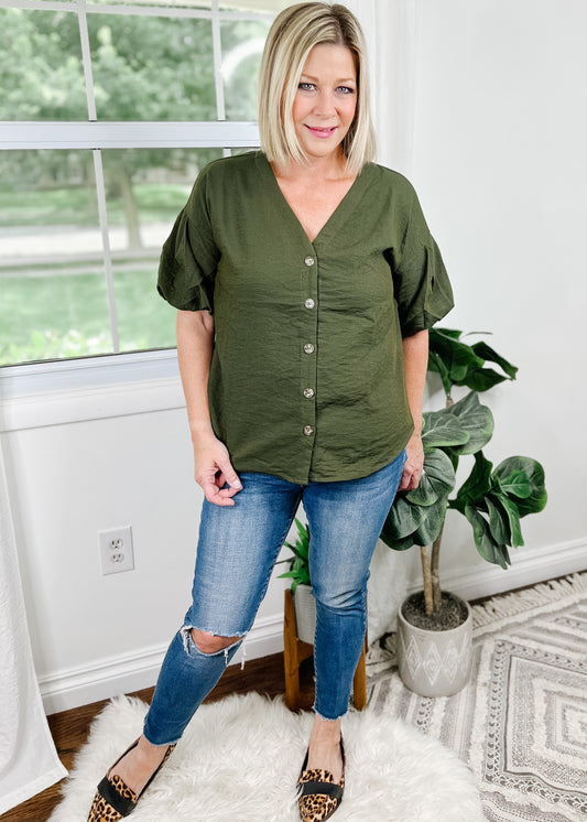 Dark green short sleeve top with bubble sleeves. Top features V-Neckline, buttons up the front and curved hemline. 