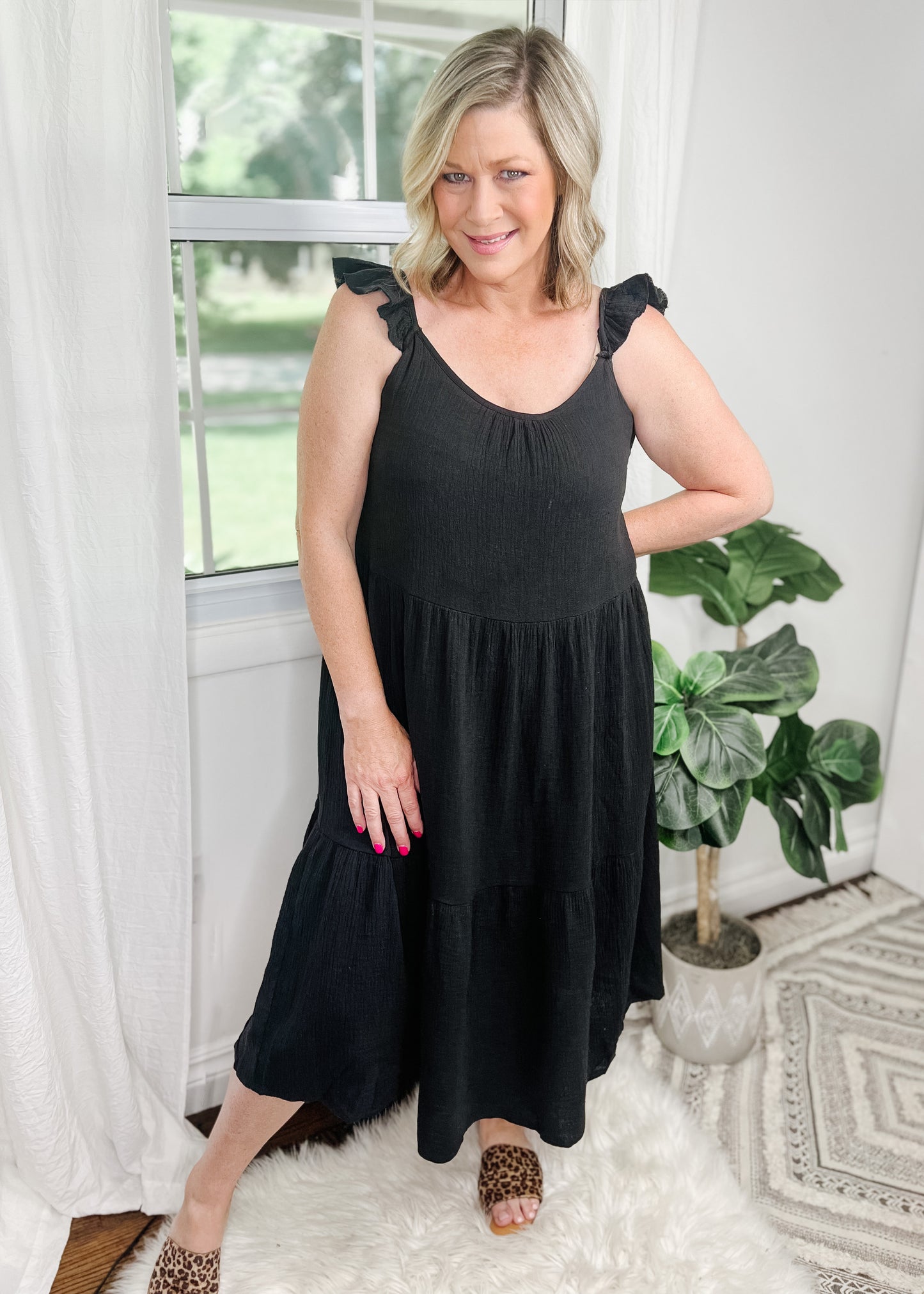 Black midi dress in a tiered style with ruffle tank straps. Made from a soft muslin fabric and is lined.