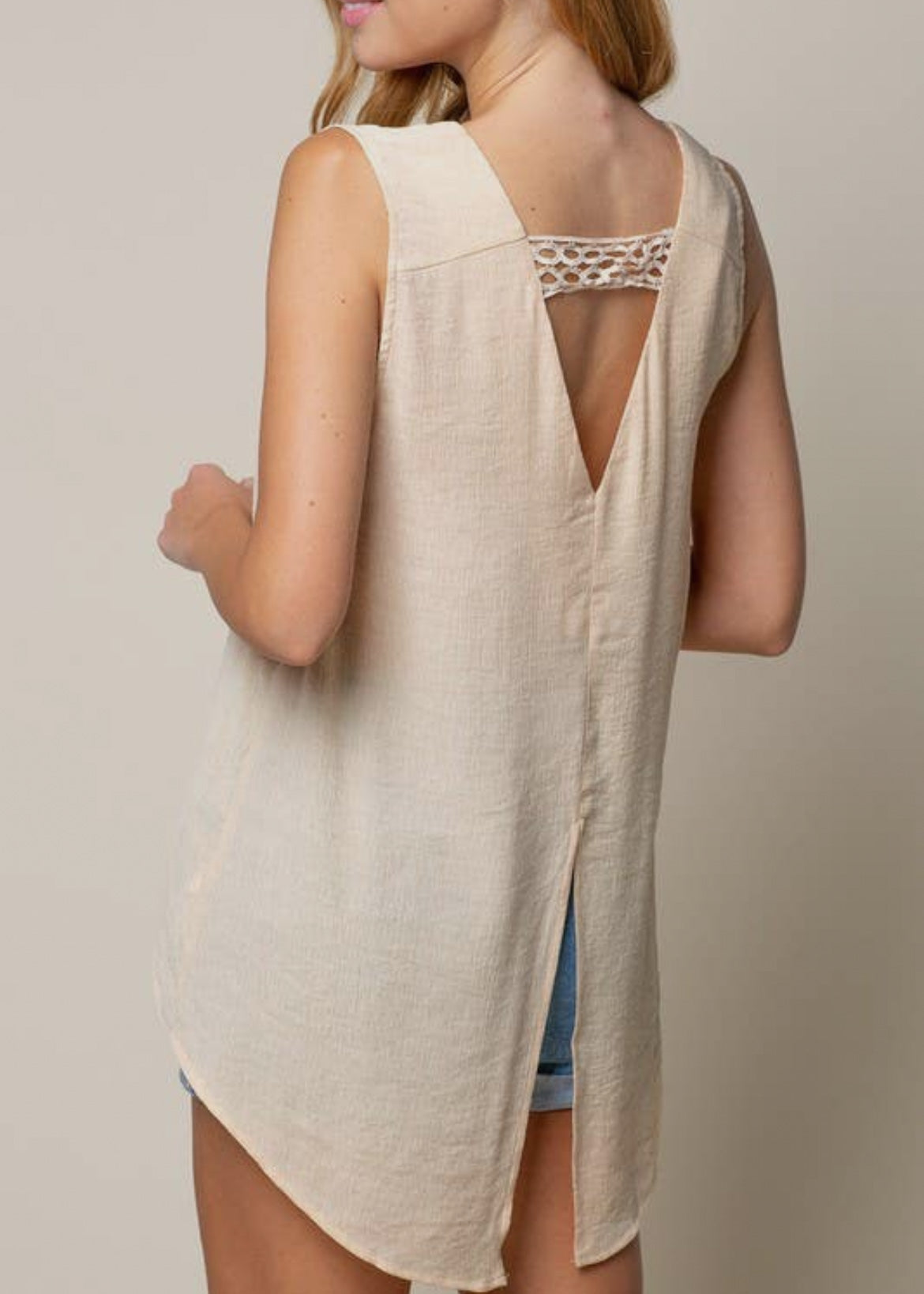 Elegant tank top in a dark cream color with a double v neckline. The back v neck has a crochet  strap and the back hemline splits up just below the waist. 