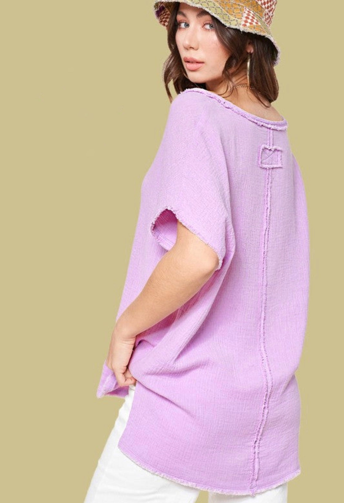 Lilac V neck top in a soft muslin fabric and raw hemlines. Short sleeves, Side slits and hi low hemline. Top features reversed stitching down the front and back center. 