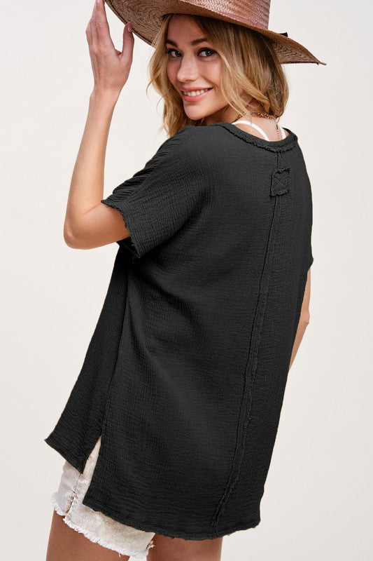 Black  V neck top in a soft muslin fabric and raw hemlines. Short sleeves, Side slits and hi low hemline. Top features reversed stitching down the front and back center. 