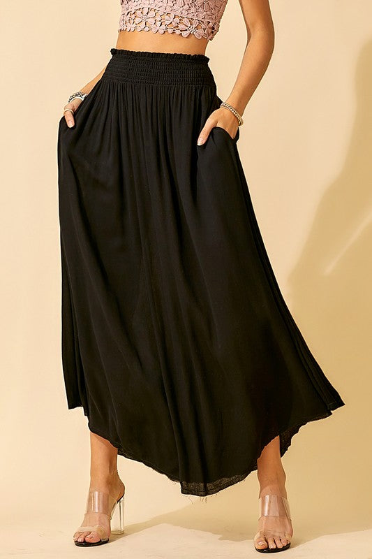 Black maxi skirt with a smocked waist, made of lightweight flowy fabric, fully lined  and has side pockets. 