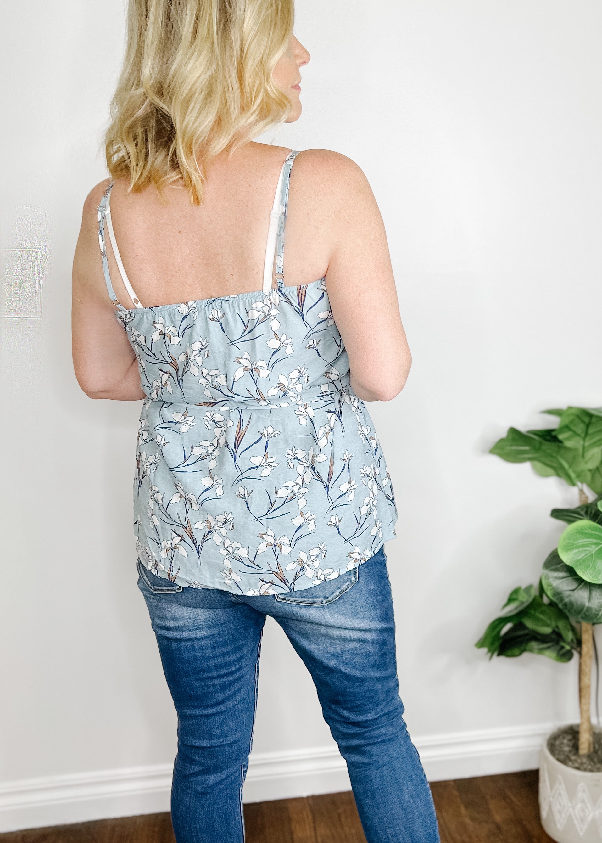 Baby blue tank top with a soft floral print. Adjustable straps, button front and front tie. 