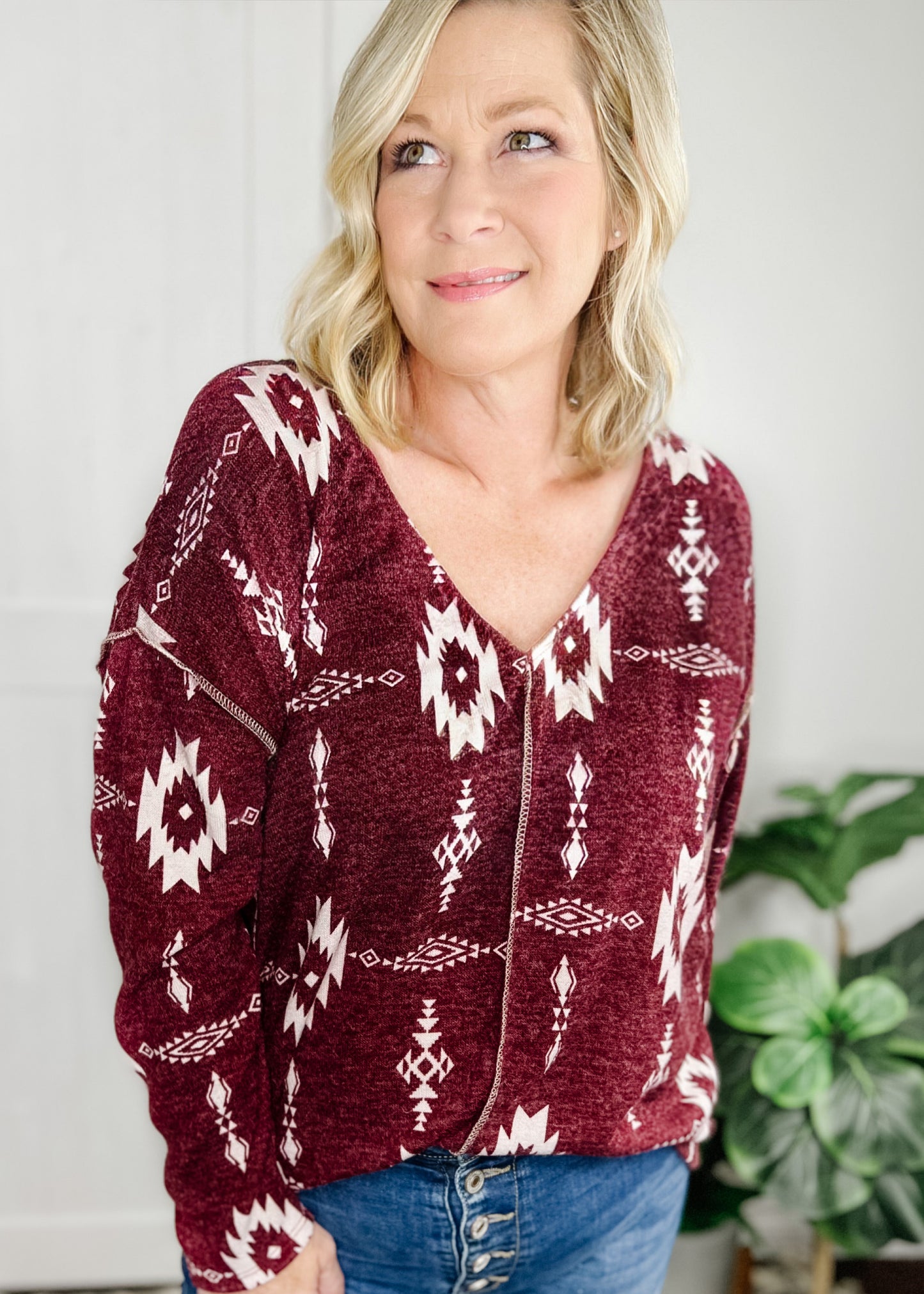Aztec print top in Burgundy. Top features, deep v neckline, long sleeves, straight hemline, stitch detail going down front and at shoulder.  Shown with out high rise skinny jeans. 