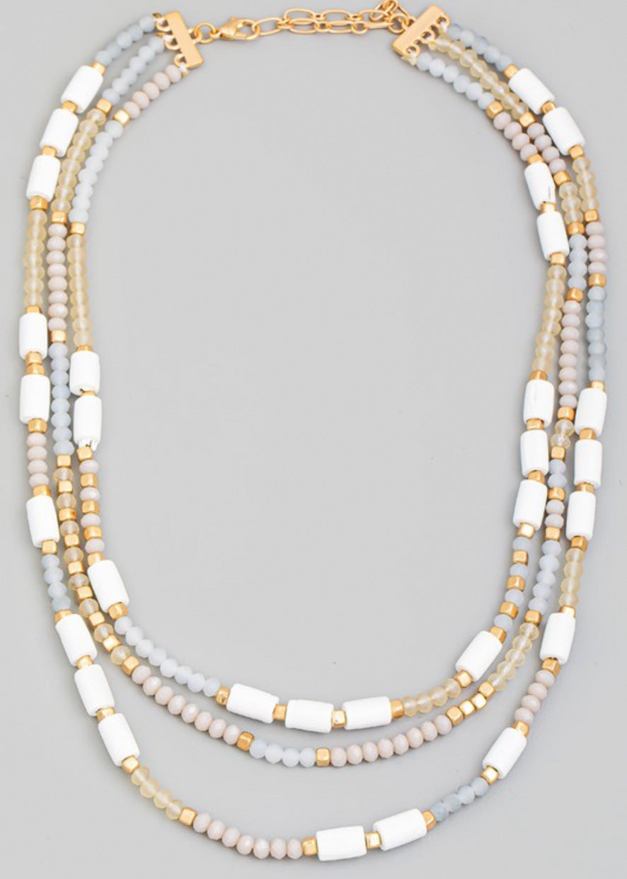 Beaded necklace with multi beads in small rounded frost and gold beads with larger white beads sporadically throughout 