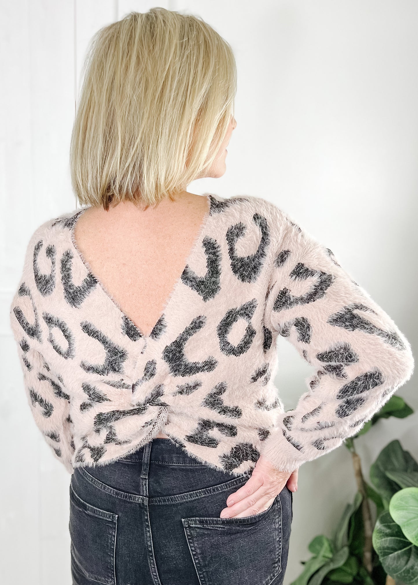 pink open back sweater in leopard print with long sleeves and rounded neckline. 
