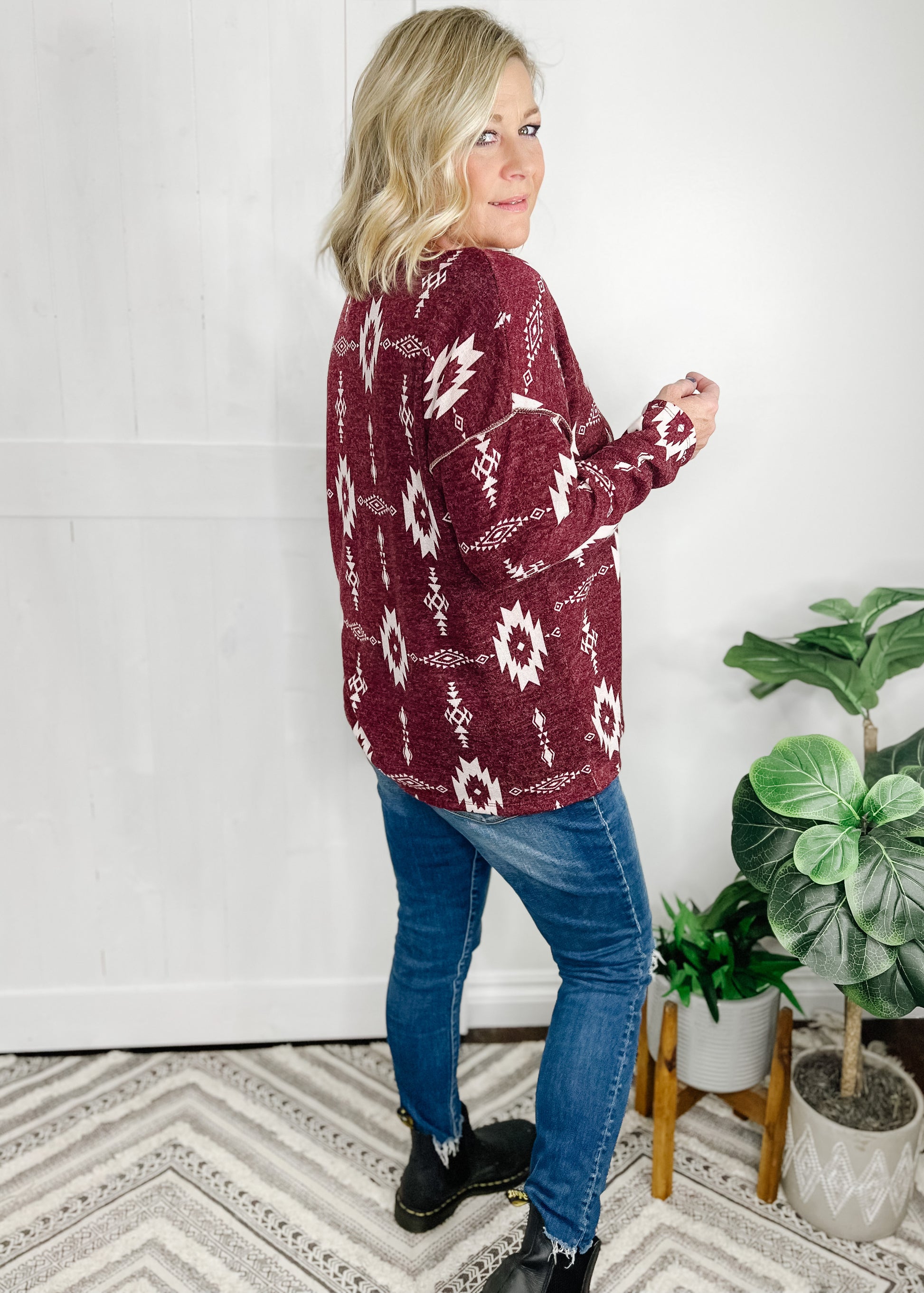 Aztec print top available in Burgundy. Top features, deep v neckline, long sleeves, straight hemline, stitch detail going down front and at shoulder.  Shown with out high rise skinny jeans. 