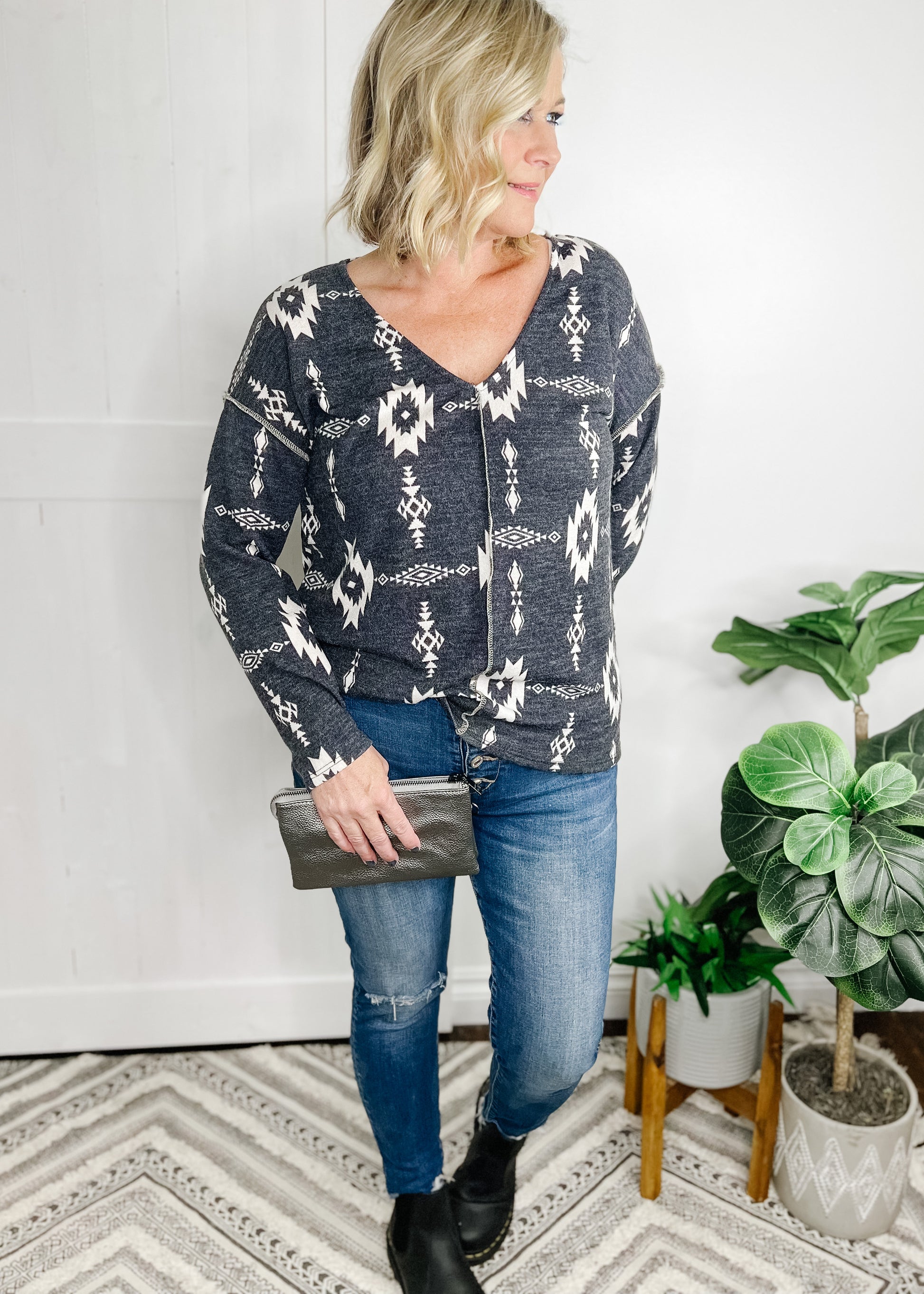 Aztec print top in  Charcoal. Top features, deep v neckline, long sleeves, straight hemline, stitch detail going down front and at shoulder.  Shown with out high rise skinny jeans. 
