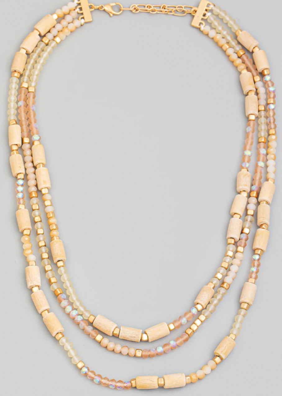 Beaded necklace with multi beads in small rounded frost and gold beads with larger tan beads sporadically throughout 