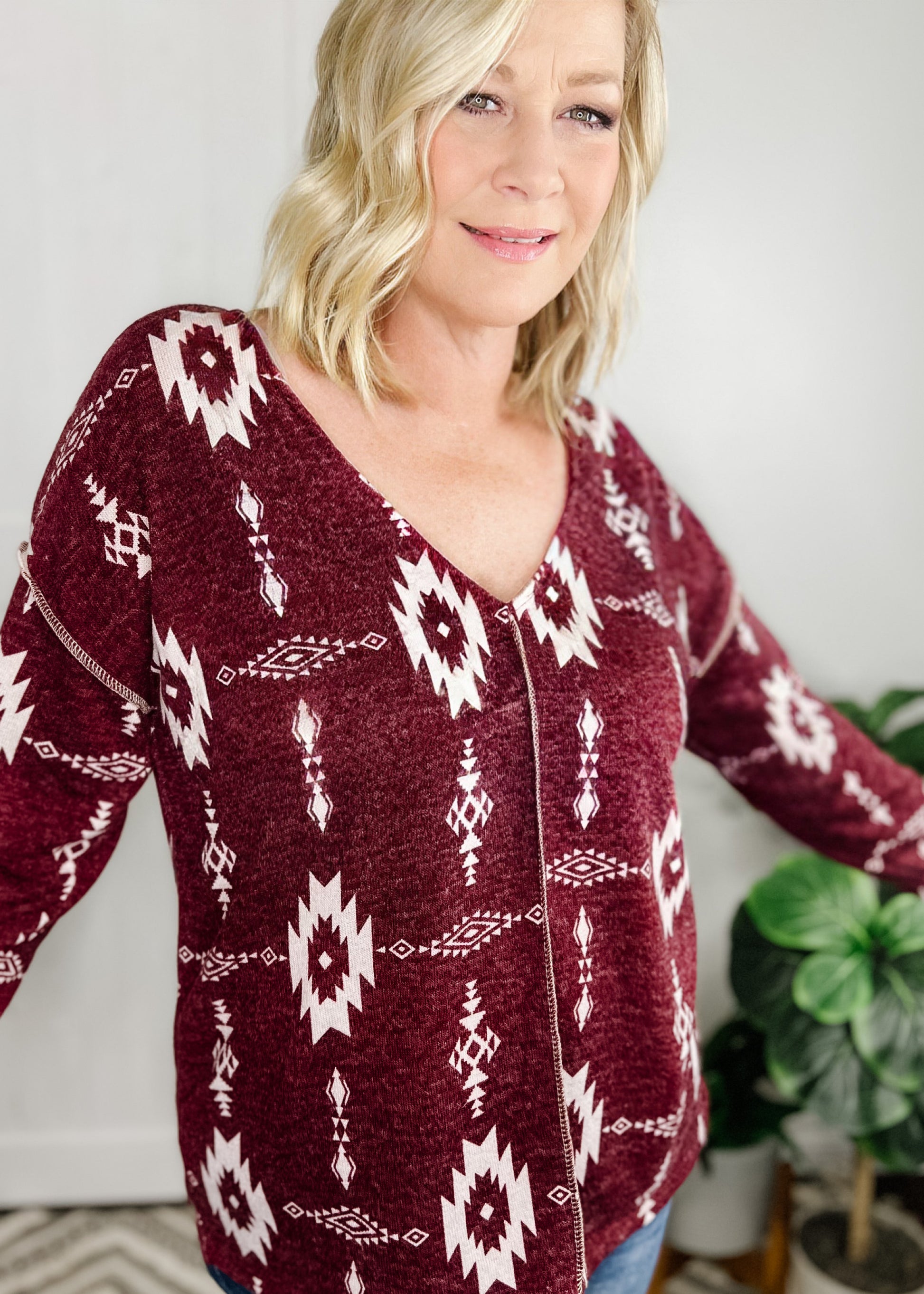 Aztec print top in Burgundy. Top features, deep v neckline, long sleeves, straight hemline, stitch detail going down front and at shoulder.  Shown with out high rise skinny jeans. 