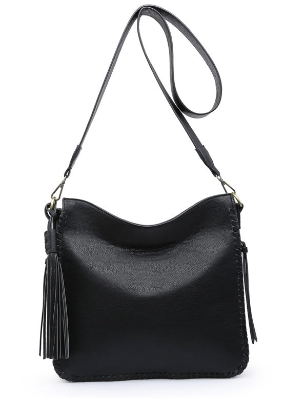 Black crossbody bag with dual zip compartments. Features detachable guitar strap with decorative side tassel, inner zip and slip pocket with back zipper pocket, side concealed pockets and whipstitch details.  Dimensions - 13 L” x 4” D x 11” H