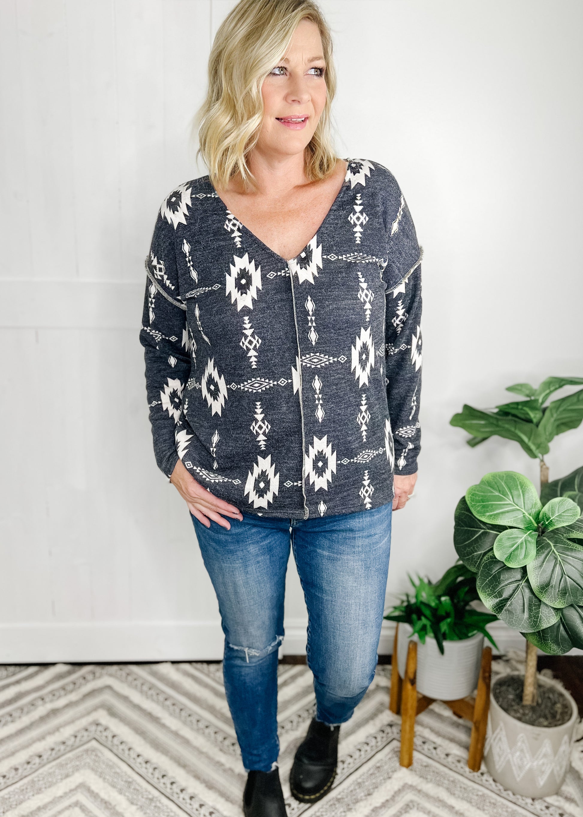 Aztec print  in Charcoal. Top features, deep v neckline, long sleeves, straight hemline, stitch detail going down front and at shoulder.  Shown with out high rise skinny jeans. 