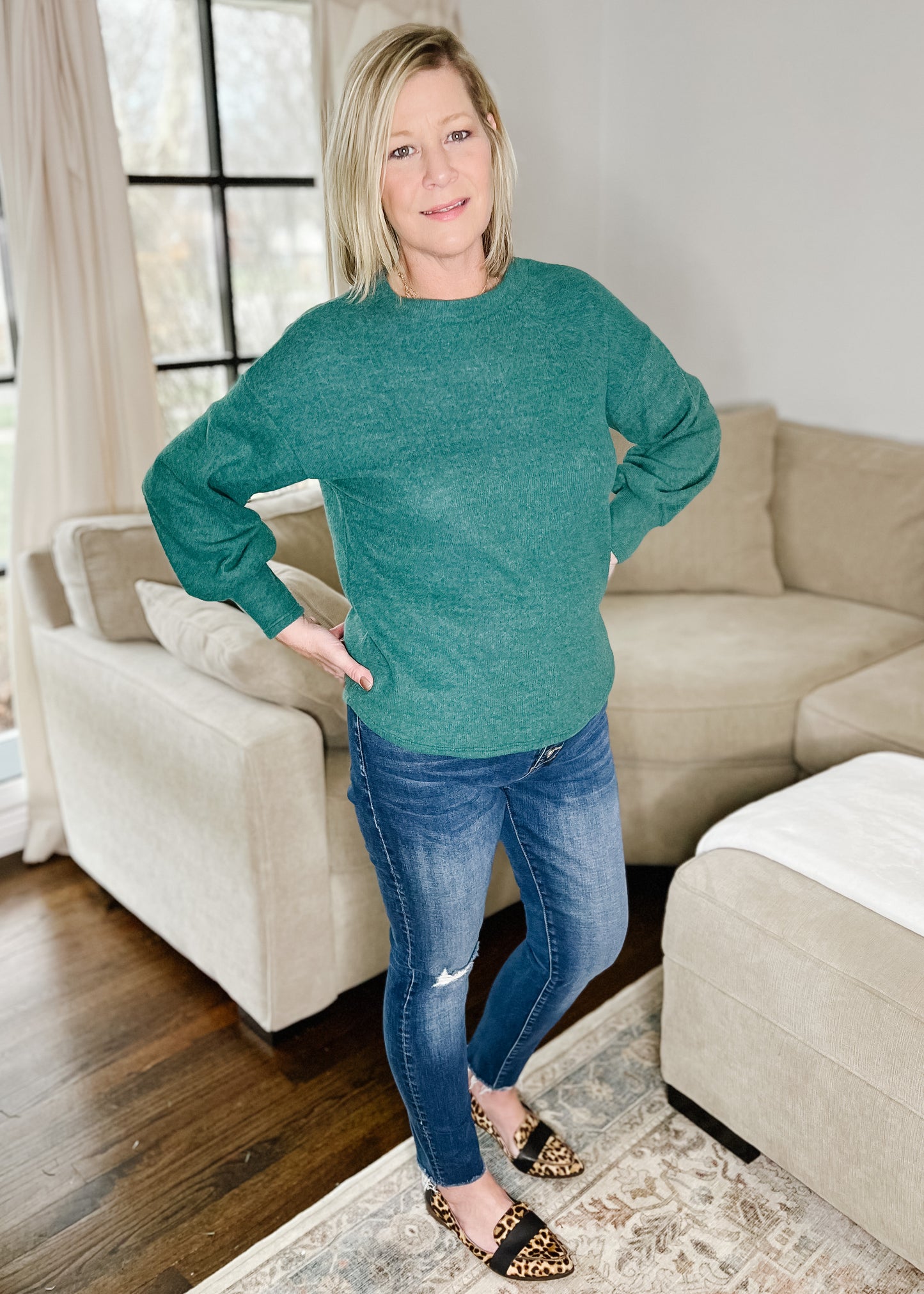Emerald green lightweight sweater with rounded neckline, slightly puffed sleeves and rounded hemline. Fixed style. 