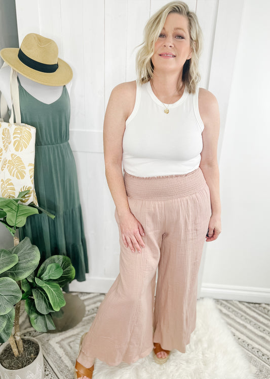 Wide pants with smocked waist in a soft neutral mauve. Fabric is a soft lightweight textured cotton. Pants have side pockets. Shown with our ribbed tank top. 